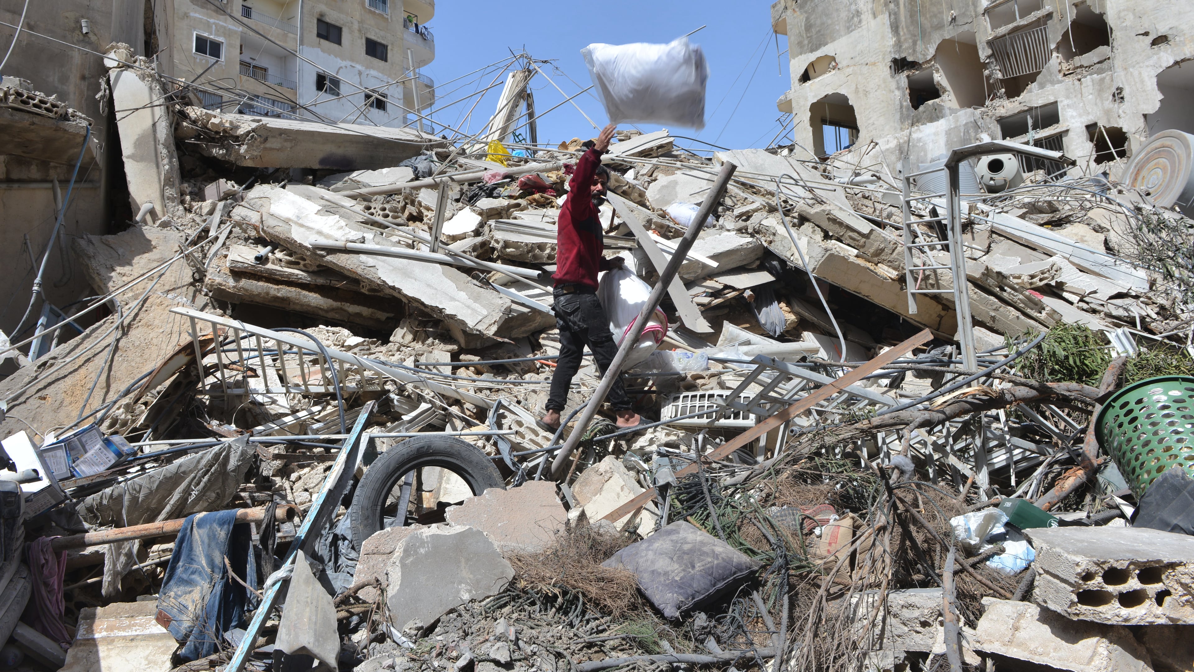 A man collects his family's belongings from the rubble of a building destroyed in an Israeli airstrike the previous day in the southern village of Maarakeh, Lebanon, Sunday, May 17, 2026. (AP Photo/Mustafa Jamalddine)