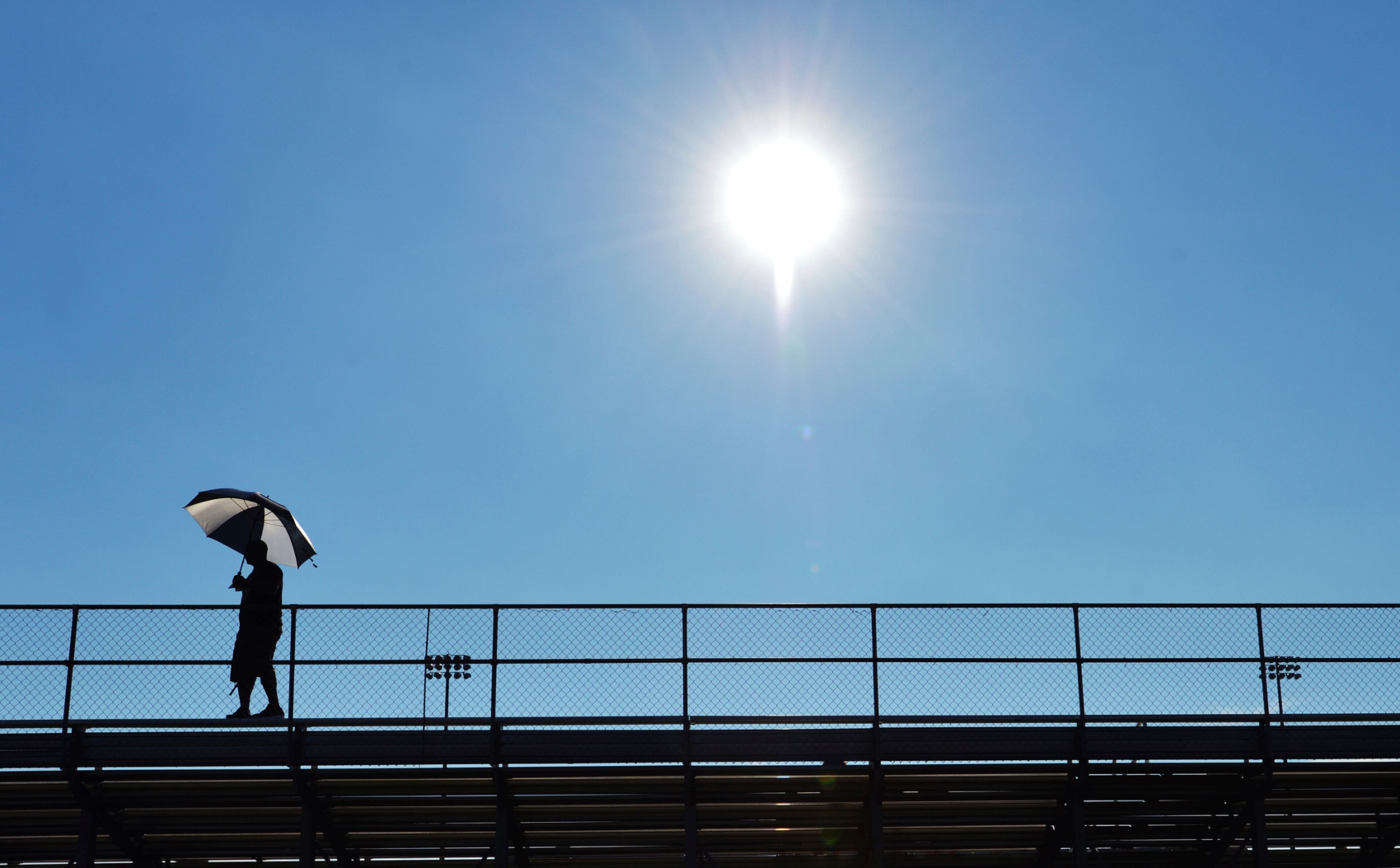 A fan watches as high school football teams participate in passing drills at Lakeshore High School Tuesday, July 18, 2017, in Stevensville, Mich. (Don Campbell/The Herald-Palladium via AP)