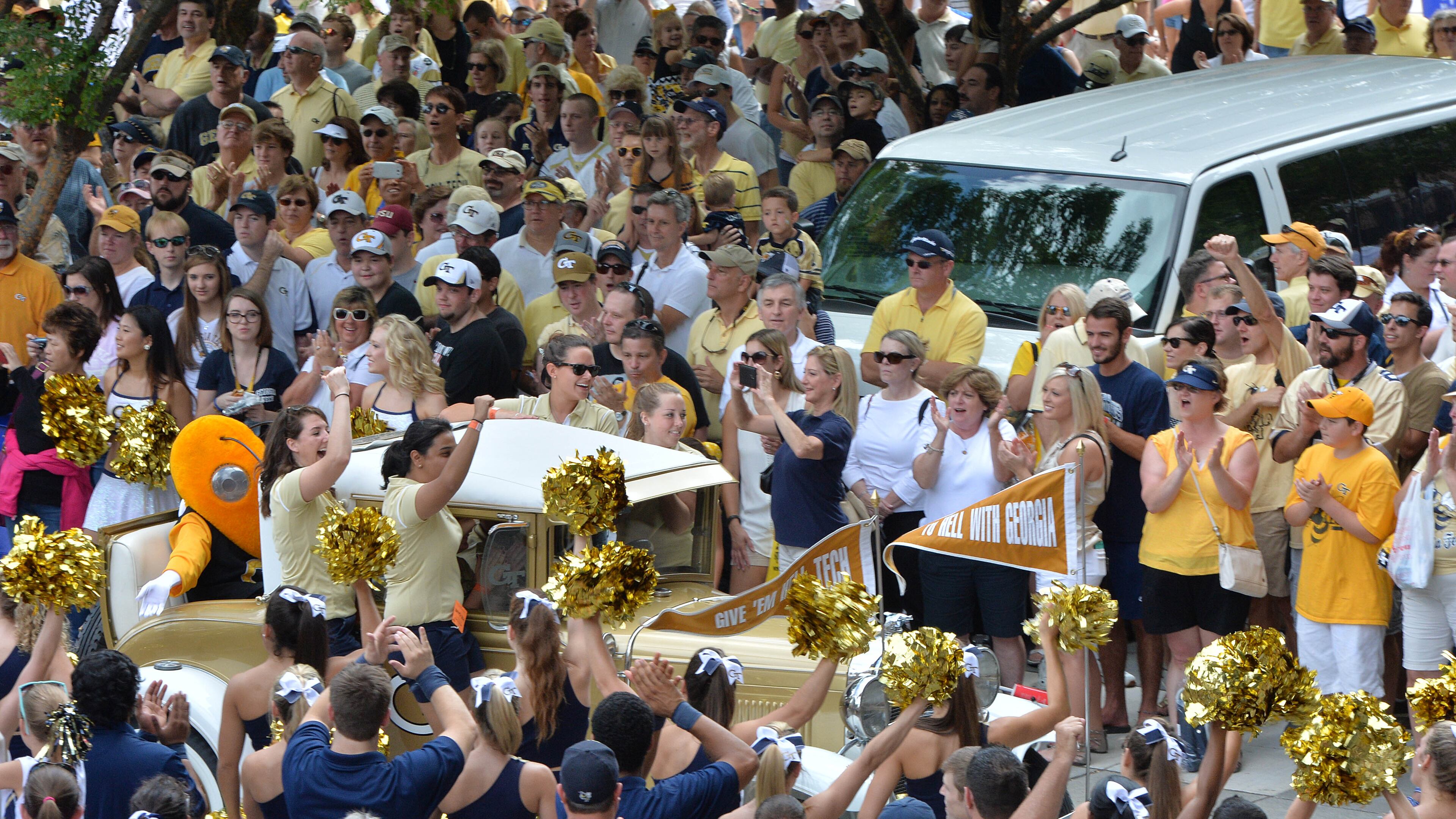 Georgia Tech’s Ramblin’ Wreck leads the band and cheerleaders through hundreds of fans down Yellow Jacket Alley before the start of the Georgia Tech season opener against the Wofford Terriers at Bobby Dodd Stadium on Saturday, August 30, 2014. HYOSUB SHIN / HSHIN@AJC.COM