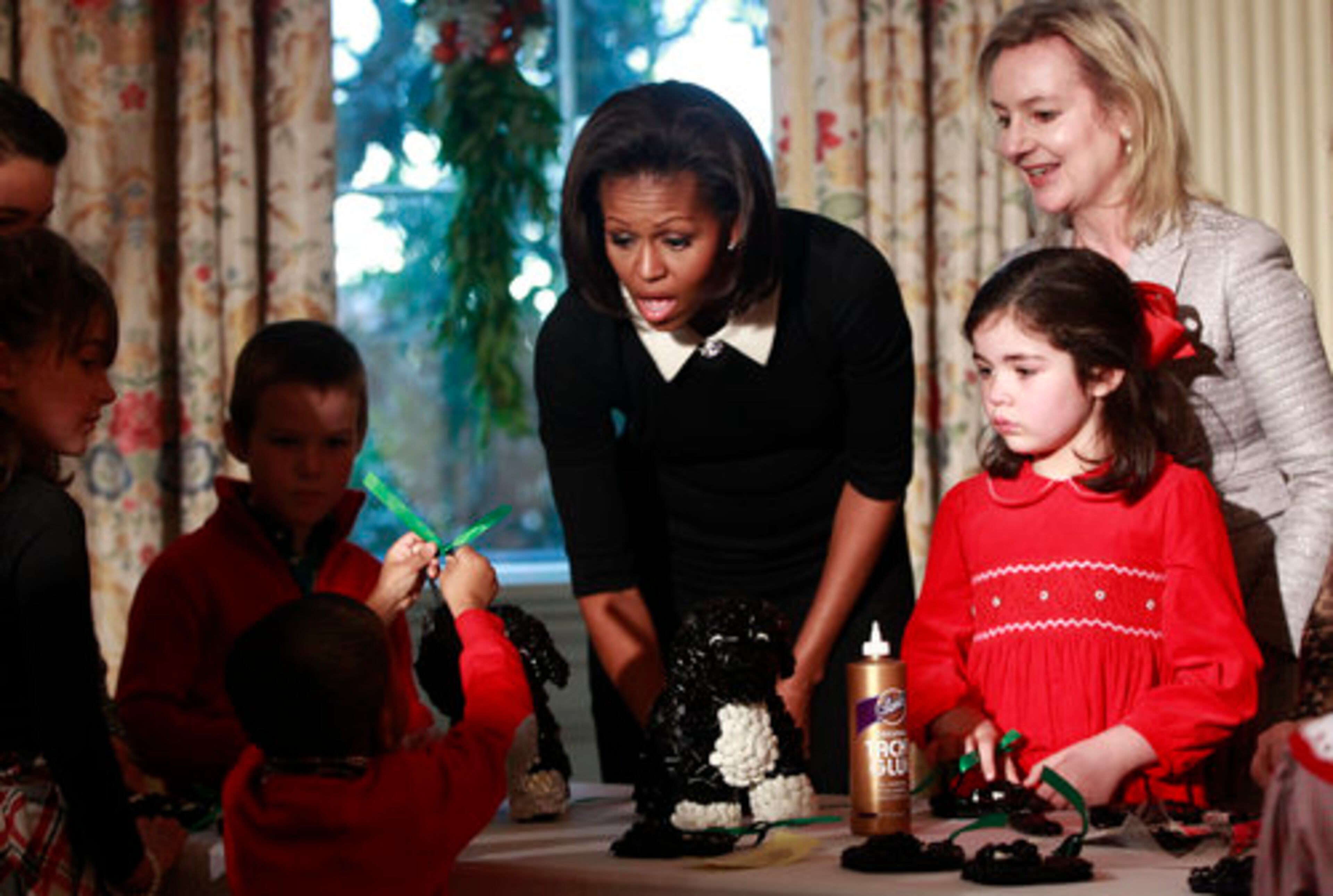 First Lady Michelle Obama joins children from military families as they decorate a rendition of Bo, the Obama family dog, made from licorice, at the White House in Washington, Wednesday, Nov. 30, 2011.