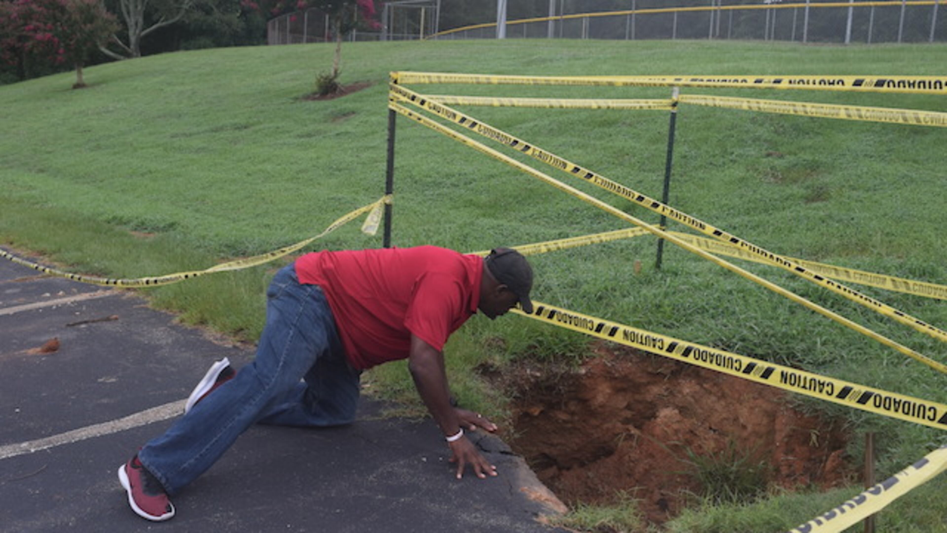 Henry County commissioner Bruce Holmes examines a large sinkhole at Cochran Park.