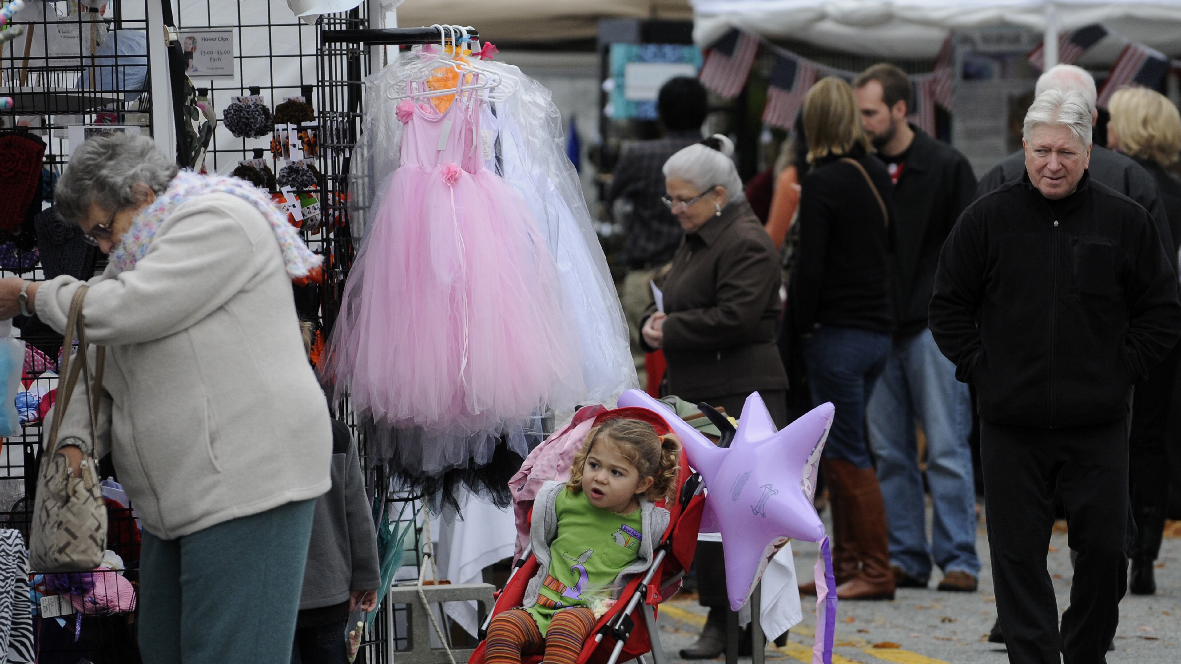 Lily Fortner, 3, peeks at artwork while her mom (not pictured) shops at the Smyrna Fall Jonquil Festival.
