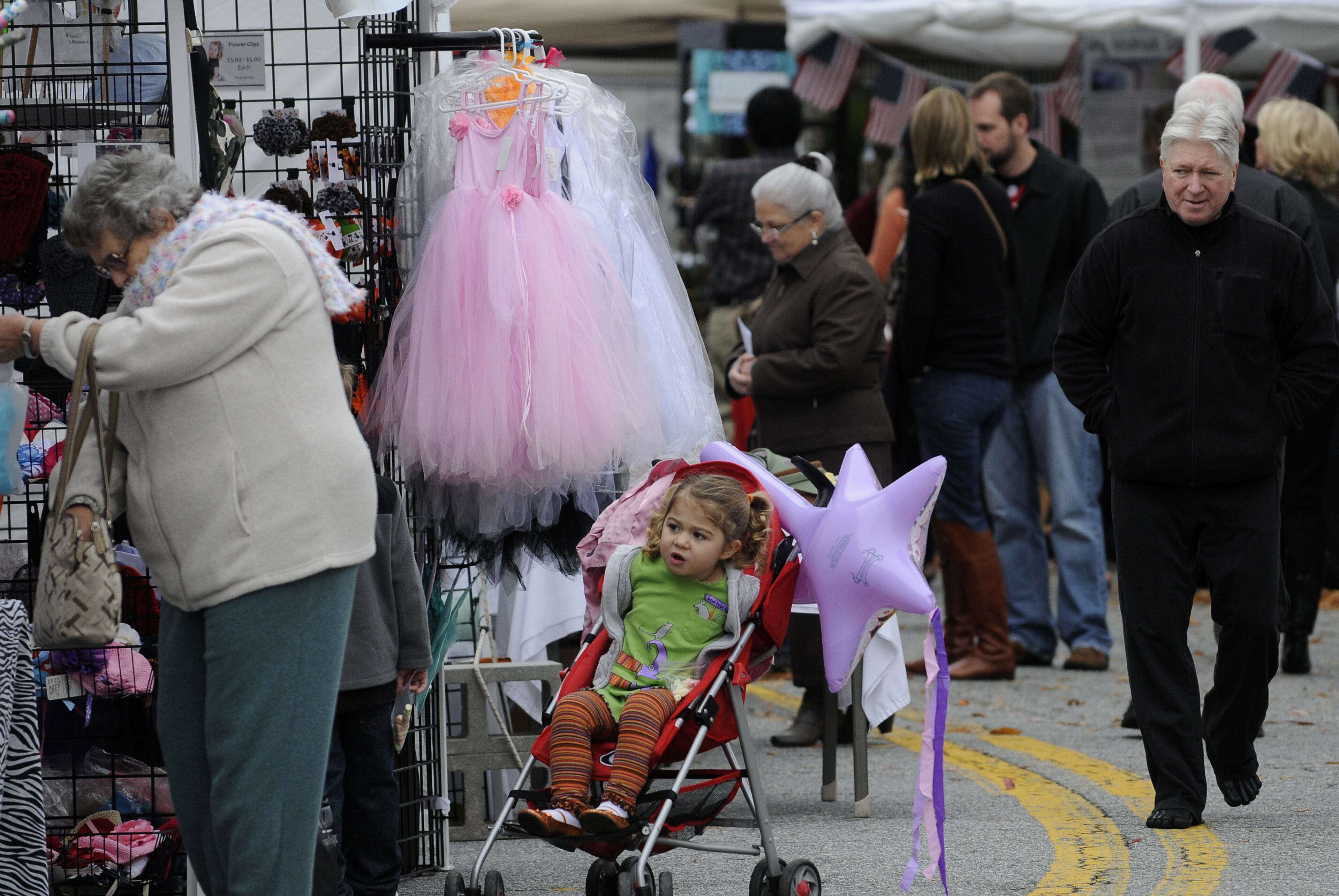 Lily Fortner, 3, peeks at artwork while her mom (not pictured) shops at the Smyrna Fall Jonquil Festival.