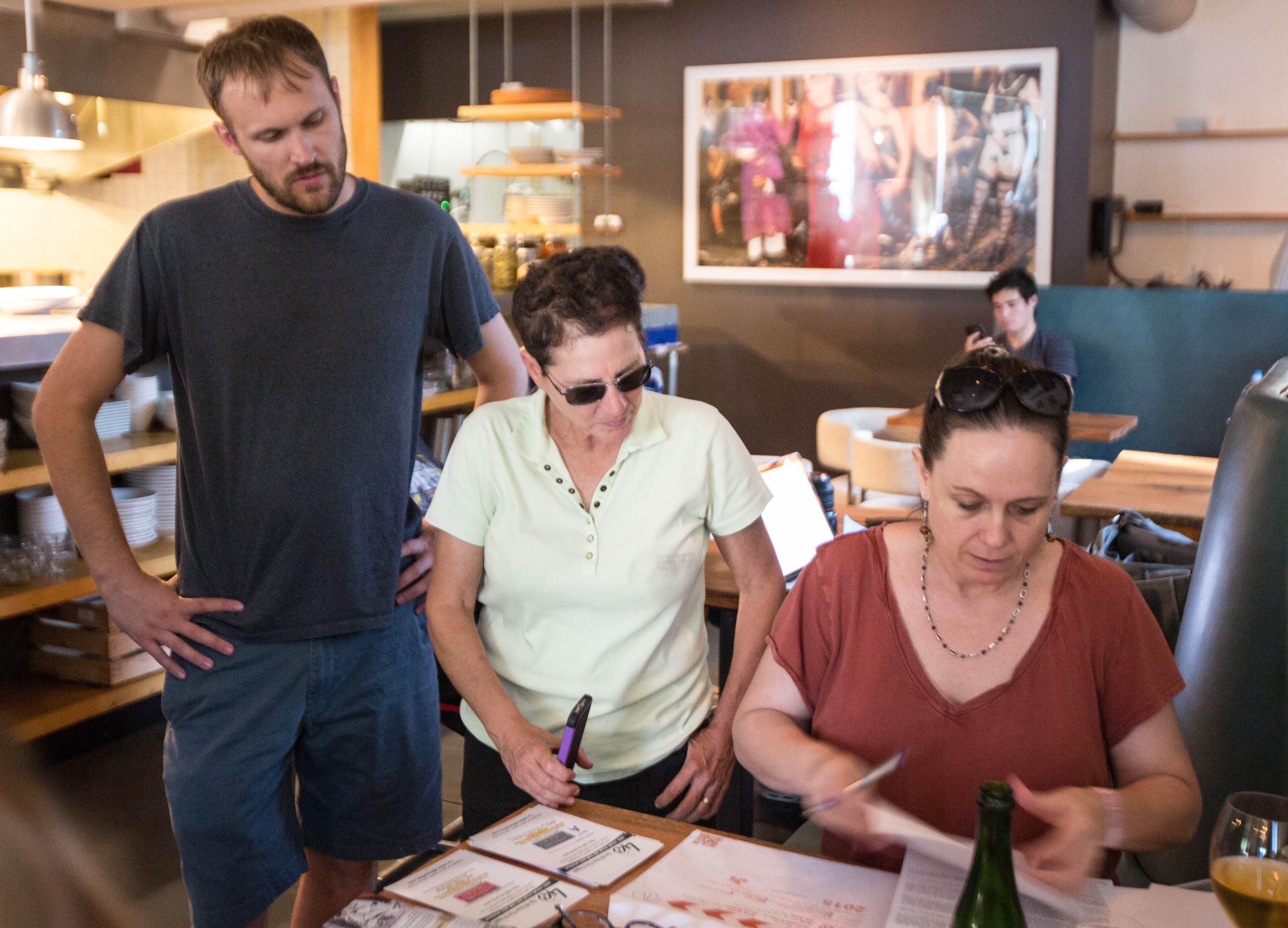 Director Jason Sheedy, left, and producer Joan Karpeles, center, submit their team's film "Re Inc." to Paula Martinez, right, less than an hour before the 48 Hour Film Project deadline at the restaurant Last Word, Sunday, June 14, 2015, in Atlanta. Teams had 48 hours to write, film, and edit a short film. BRANDEN CAMP/SPECIAL