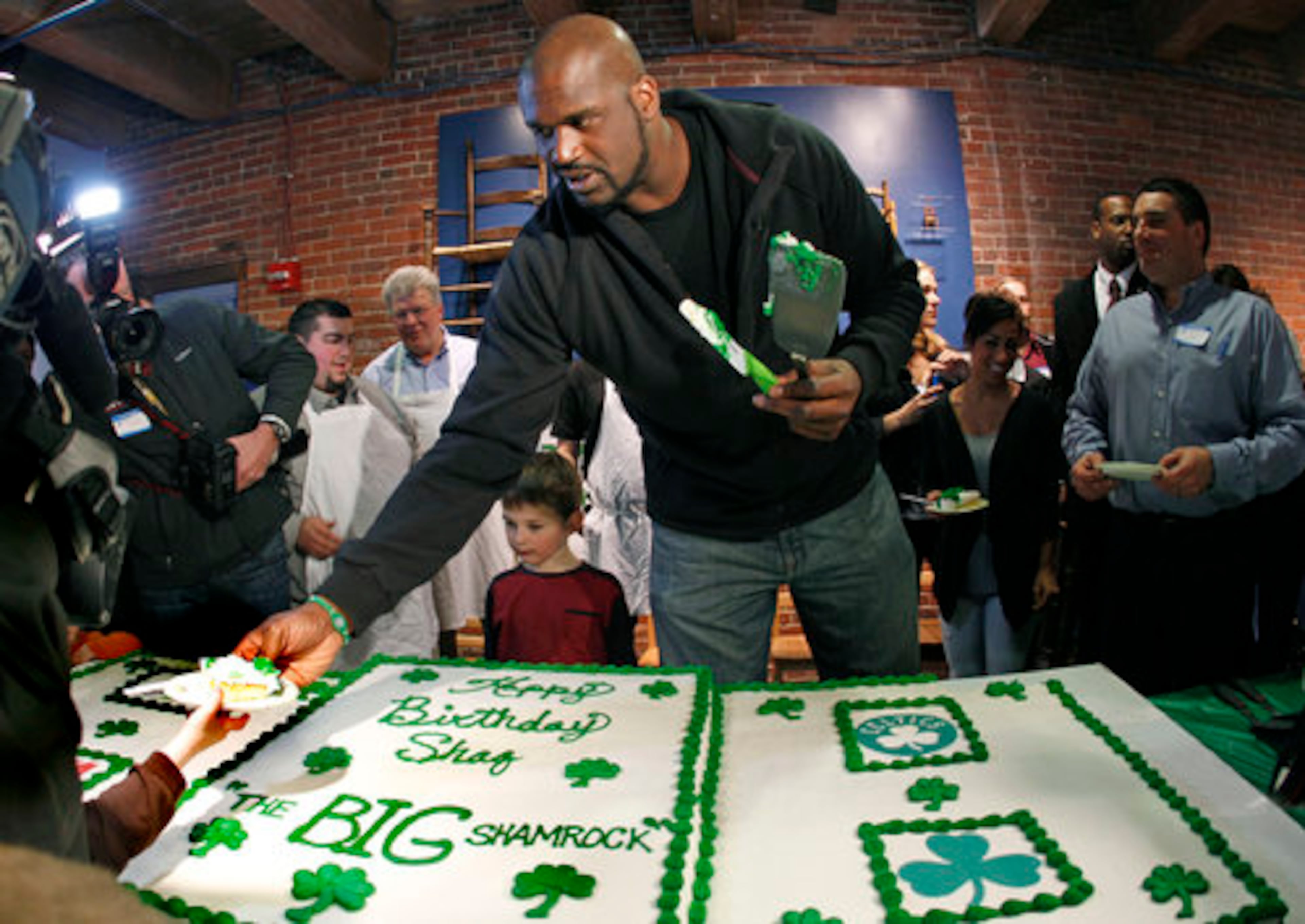 Boston Celtics basketball star Shaquille O'Neal hands out birthday cake at the Children's Museum to celebrate his 39th birthday, Monday, March 7, 2011, in Boston.