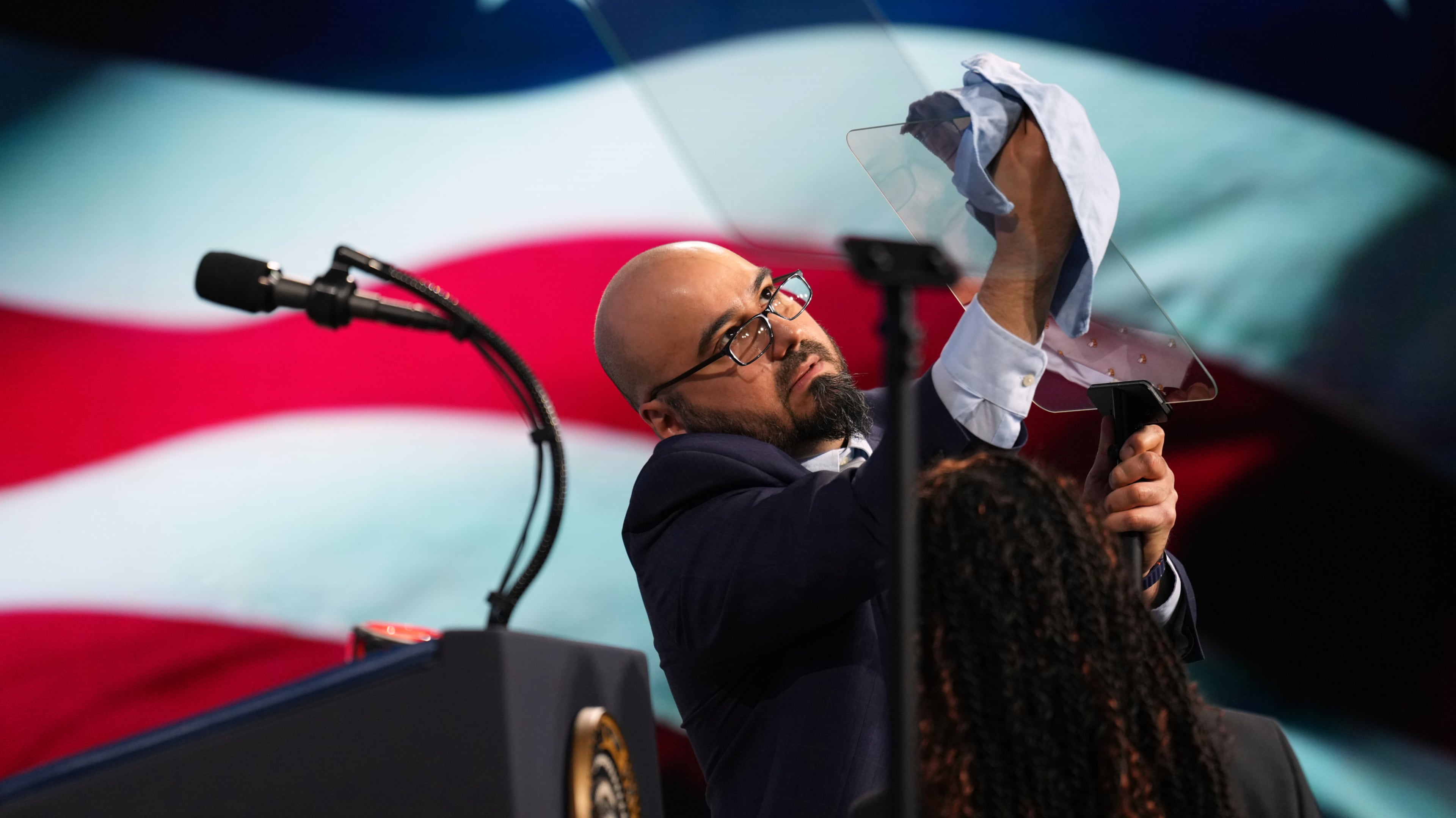 FILE - Gabriel Perez cleans the teleprompter before President Donald Trump speaks at the Future Investment Initiative Institute's summit, March 27, 2026, in Miami Beach, Fla. (AP Photo/Mark Schiefelbein, File)
