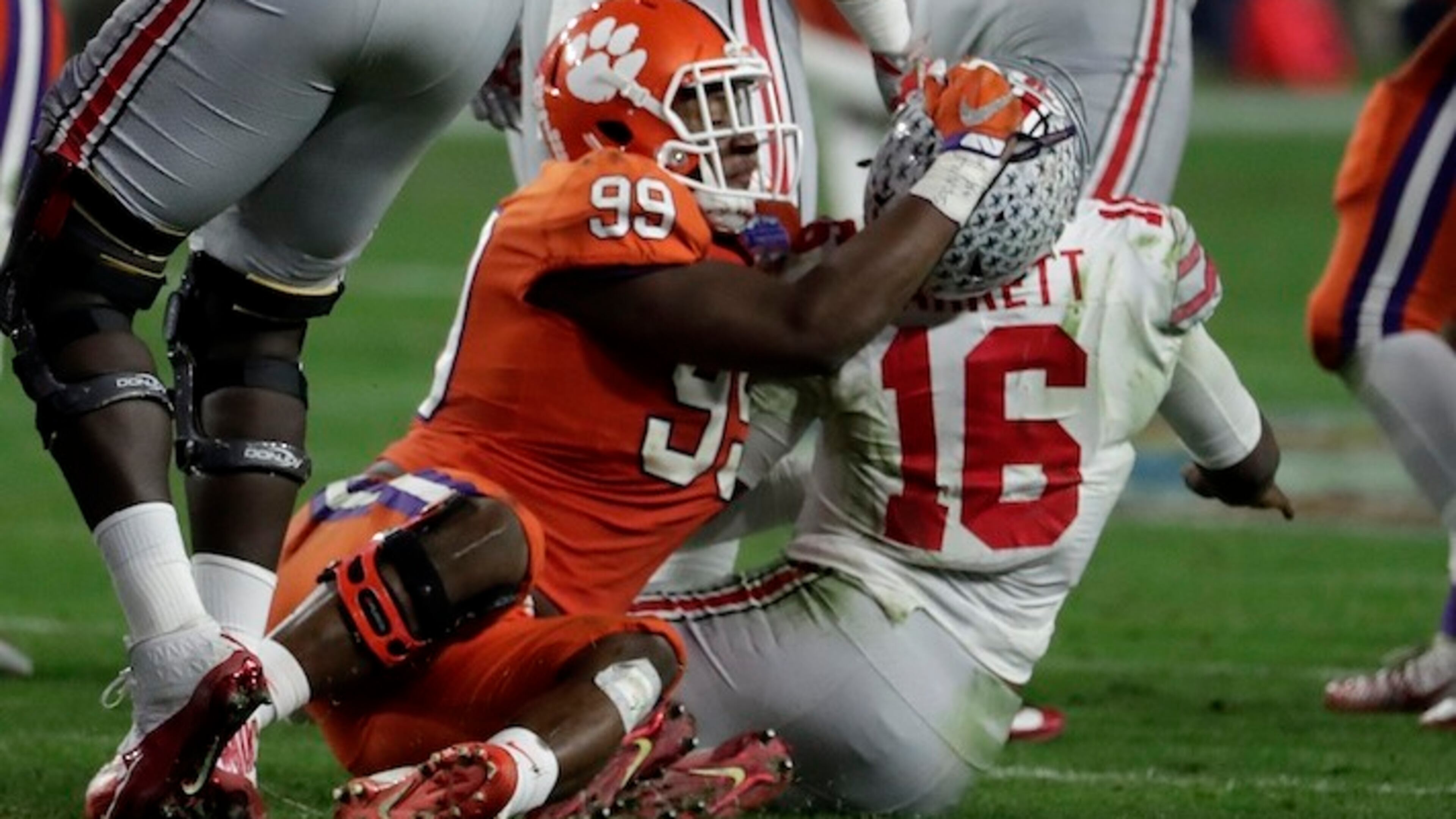 Clemson defensive end Clelin Ferrell (99) grabs Ohio State quarterback J.T. Barrett (16) after the throw during the second half of the Fiesta Bowl NCAA college football game, Saturday, Dec. 31, 2016, in Glendale, Ariz. (AP Photo/Rick Scuteri)