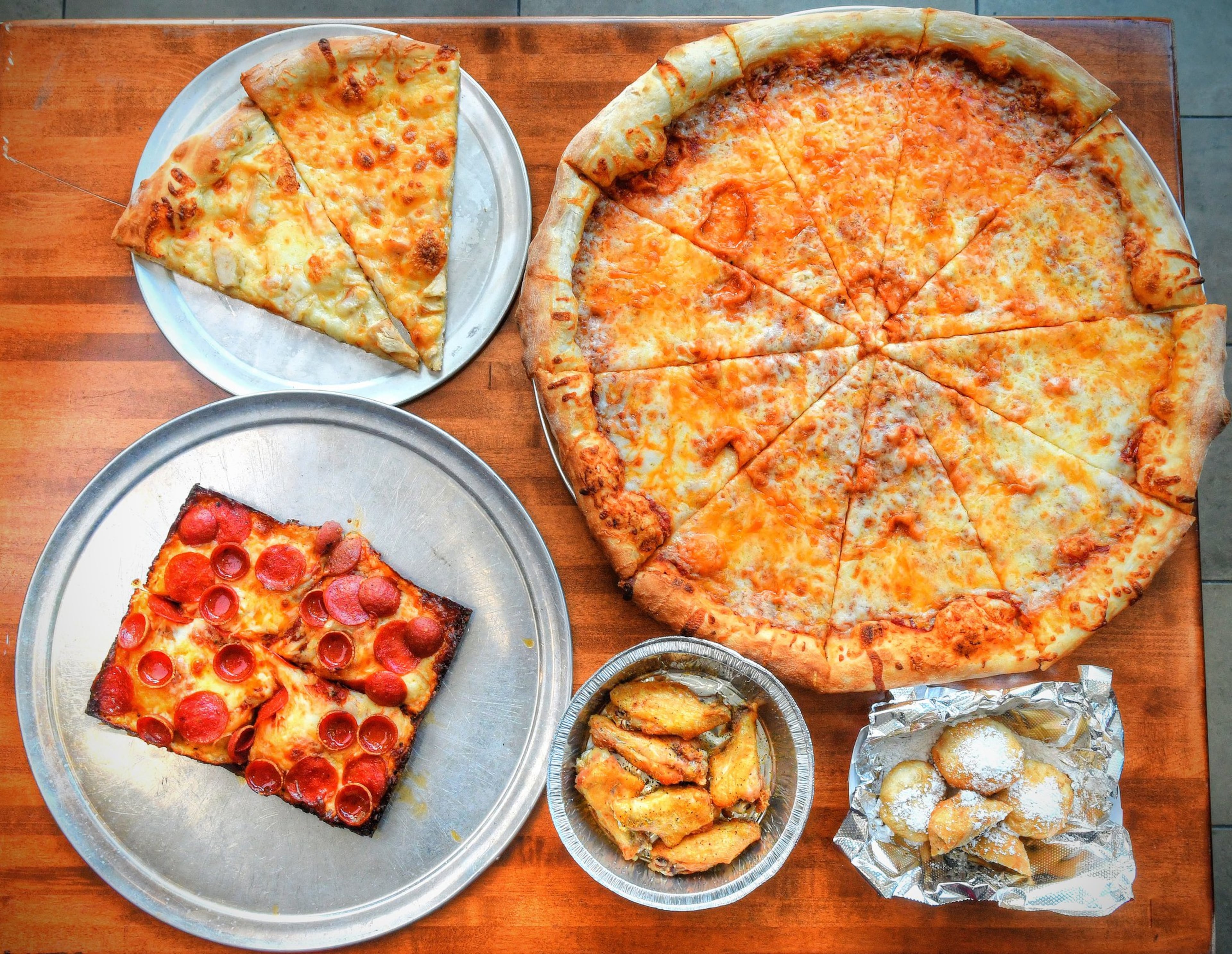 Top row from left: New York Style Chicken Alfredo pizza, New York Style Cheese pizza. Bottom row from left: Detroit Style Pepperoni pizza, Lemon Pepper Wings, Fried Oreos at Triple Jay's Pizza. (Contributed by Chris Hunt Photography)