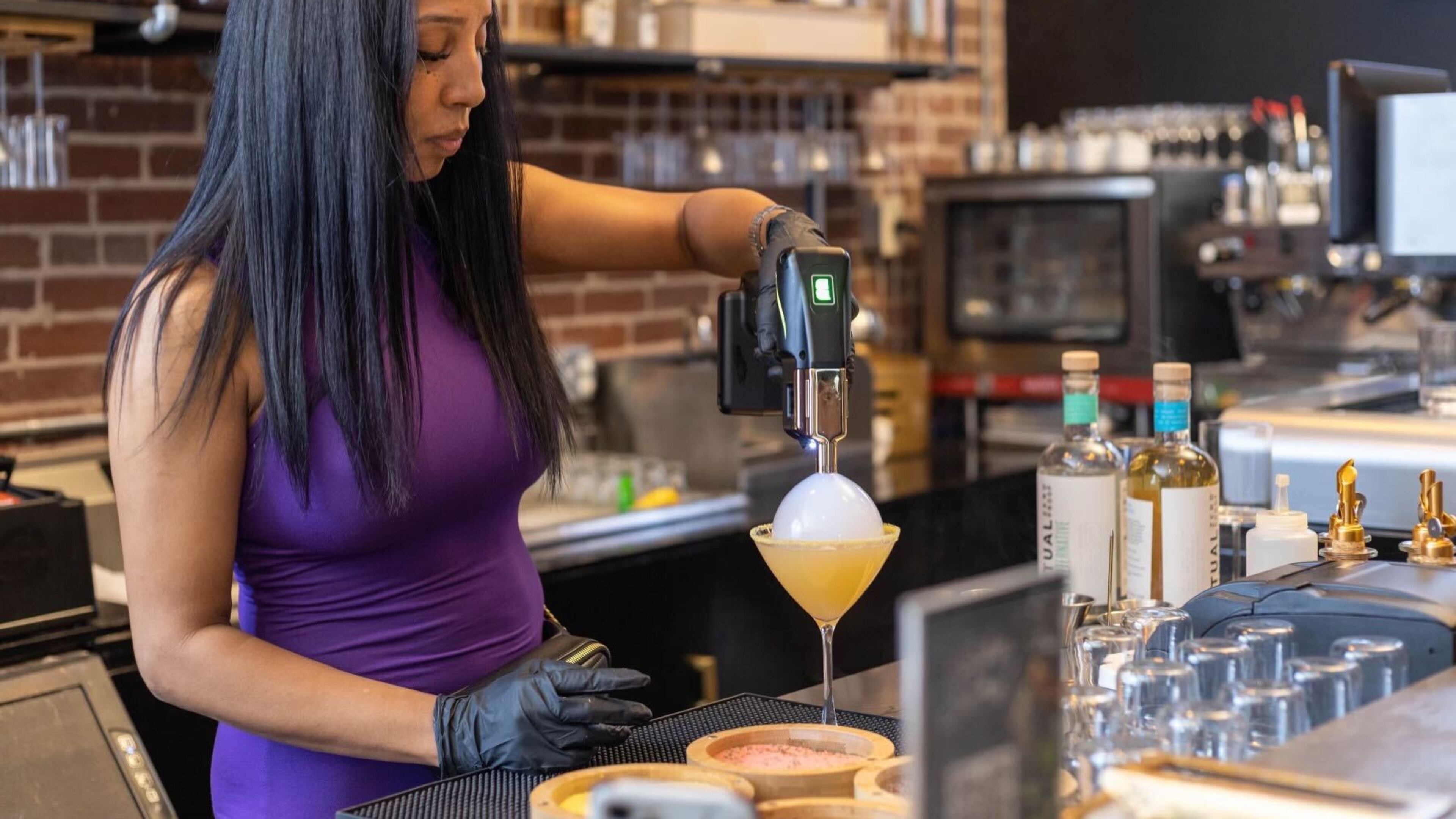 Aja Wolfe, the owner of Sober Social in Castleberry Hill, mixes a nonalcoholic drink behind the bar. / Courtesy of Aja Wolfe