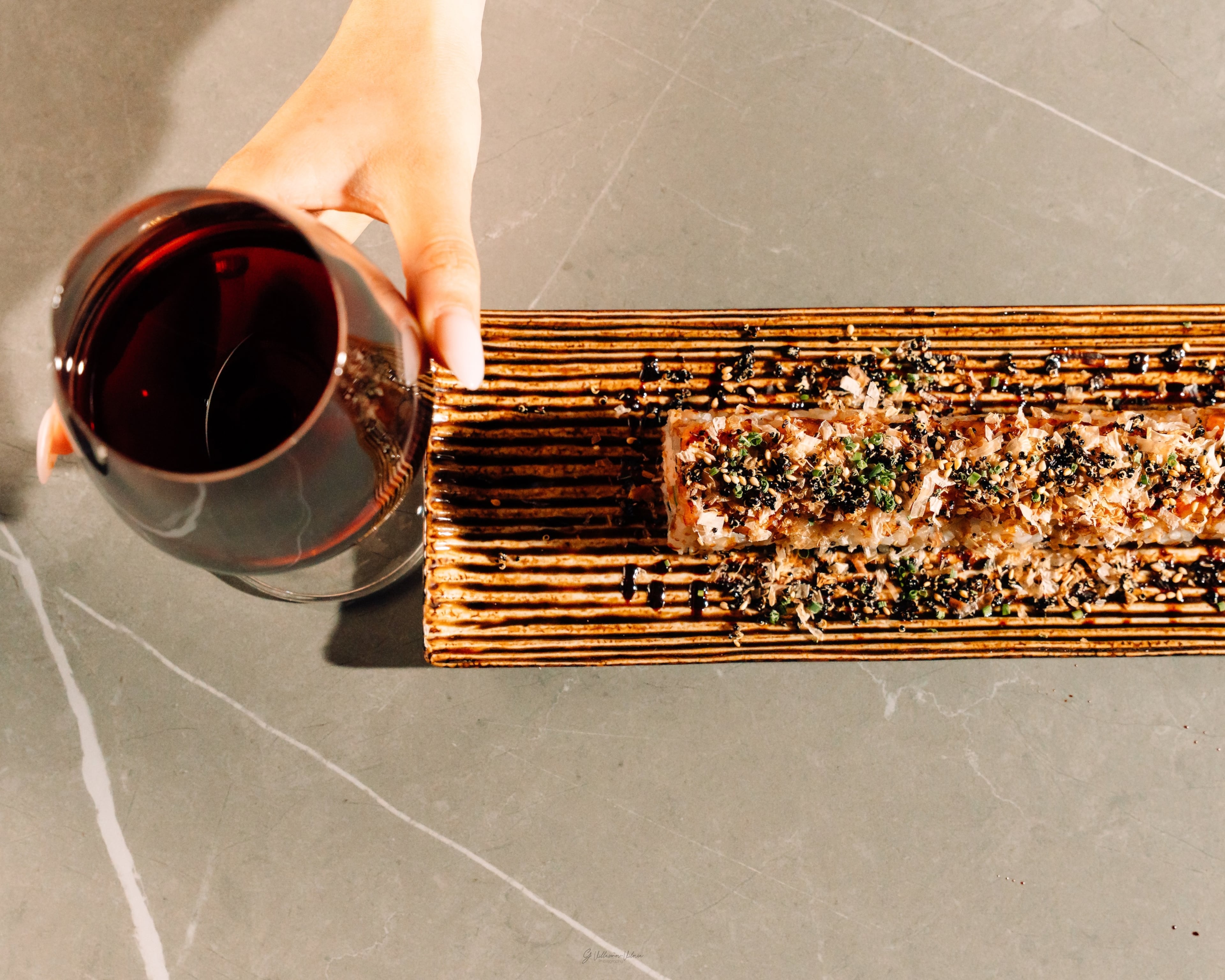 A glass of wine complements a sushi roll at NoriFish. (JETPVCK Media/Courtesy of NoriFish and Okiboru)