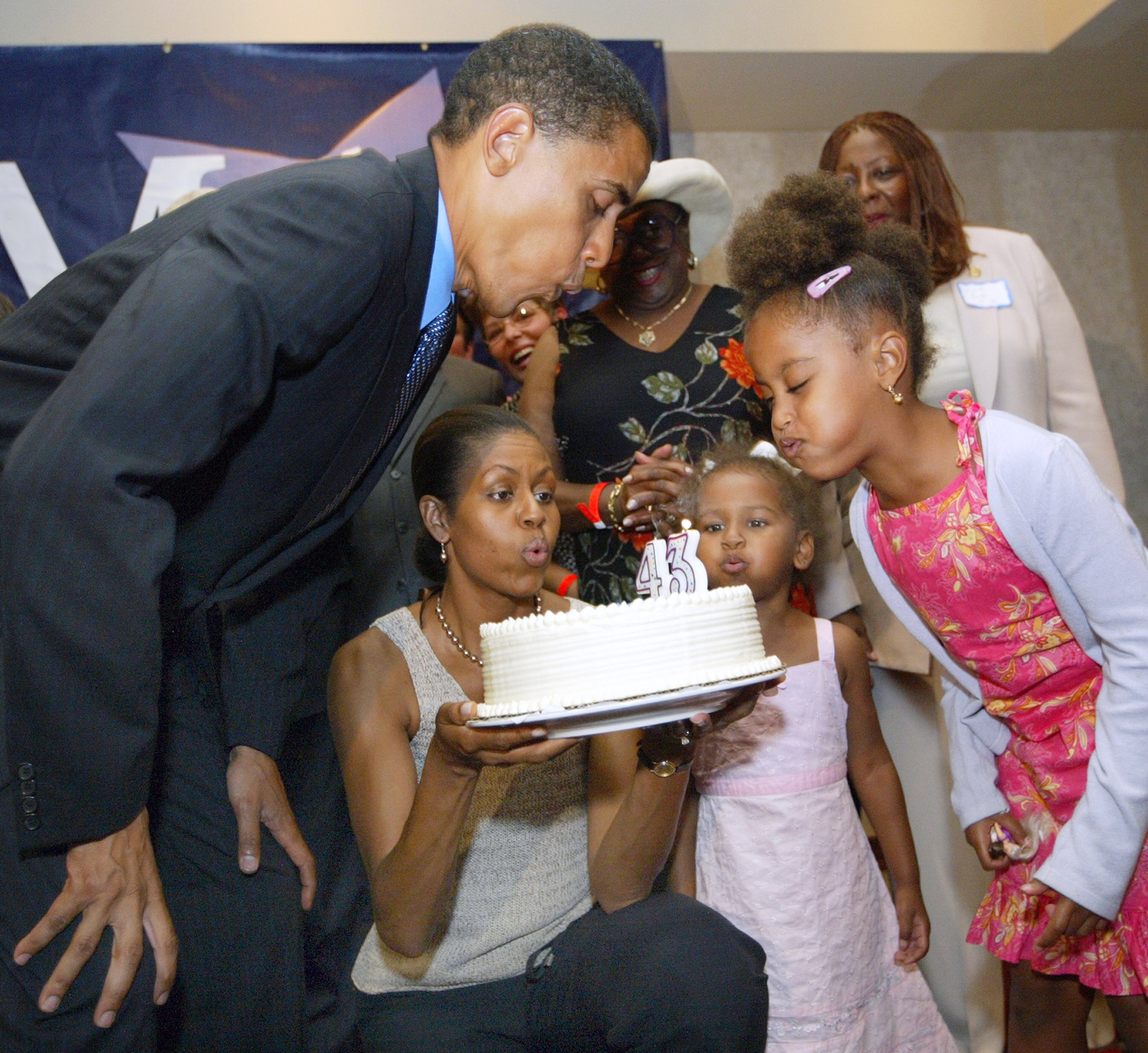 Barack Obama blows out candles on his birthday cake at his 43rd birthday celebration with his wife Michelle, who is holding the cake, and daughters Sasha and Malia (R) during a fundraiser August 4, 2004 in Matteson, Illinois. Obama is the Democratic candidate from Illinois running for the U.S. Senate and currently represents Illinois' 13th Senate District on Chicago' s South Side. (Photo by Tim Boyle/Getty Images)