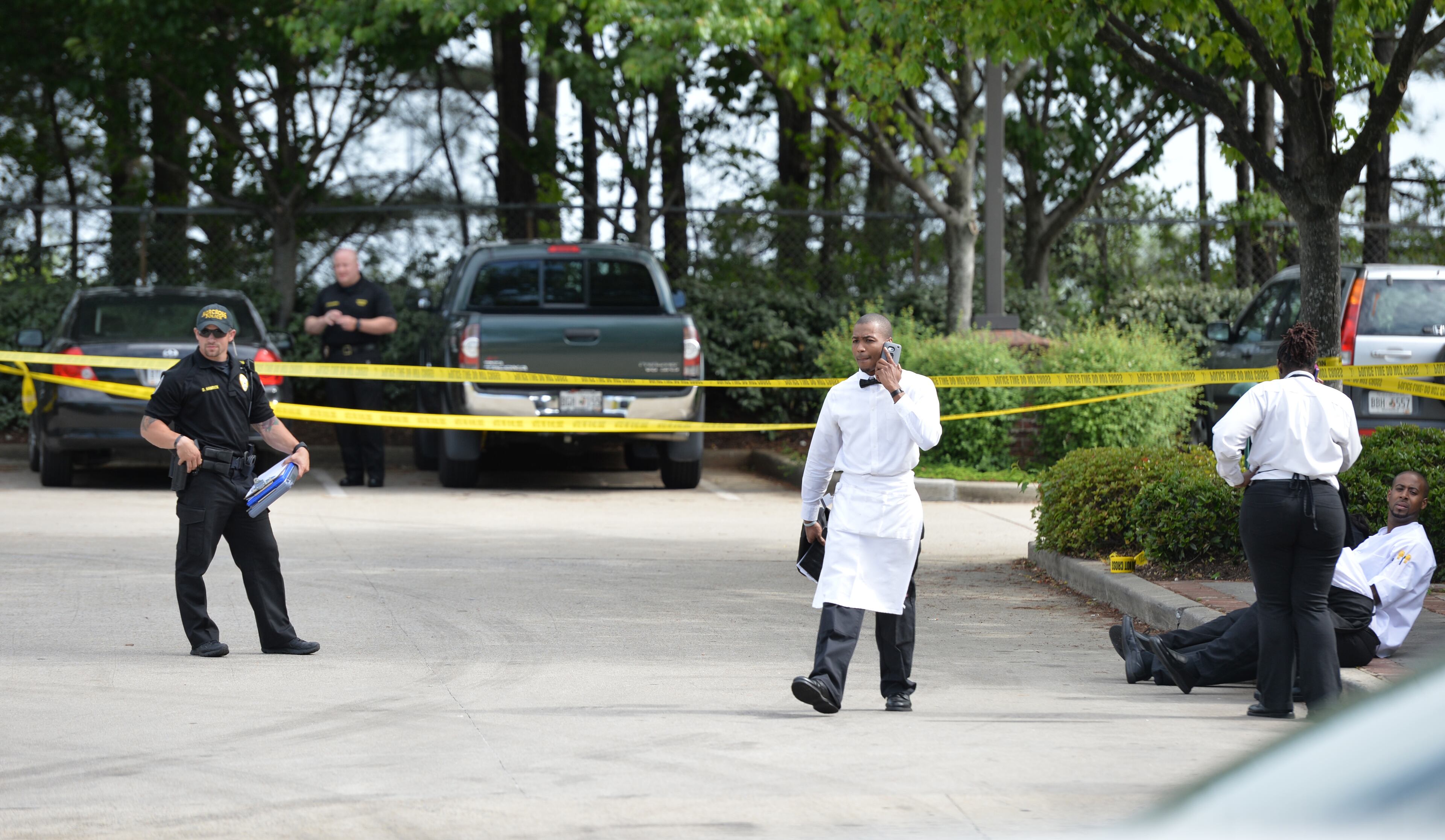 Authorities investigate in the presence of restaurant employees in the parking lot of Pappadeaux Seafood Kitchen, where at least one victim was shot multiple times, near the intersection of I-85 and Jimmy Carter Boulevard in Norcross on Friday afternoon, May 2, 2014. HYOSUB SHIN / HSHIN@AJC.COM
