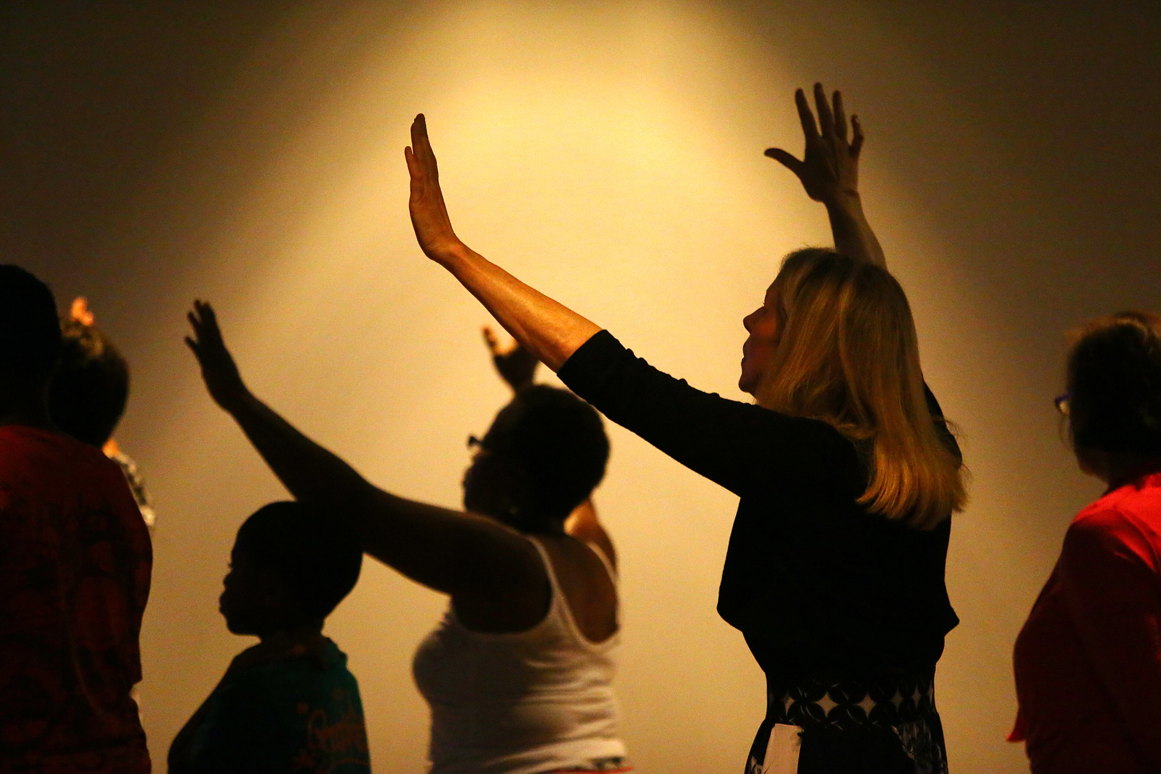 14-year attendee Debbie Fox (right) and new visitor Patricia Teal raise their arms during worship music on "Anniversary Sunday" the 17th year of the City of Refuge on Sunday, July 13, 2014, in Atlanta. CURTIS COMPTON / CCOMPTON@AJC.COM