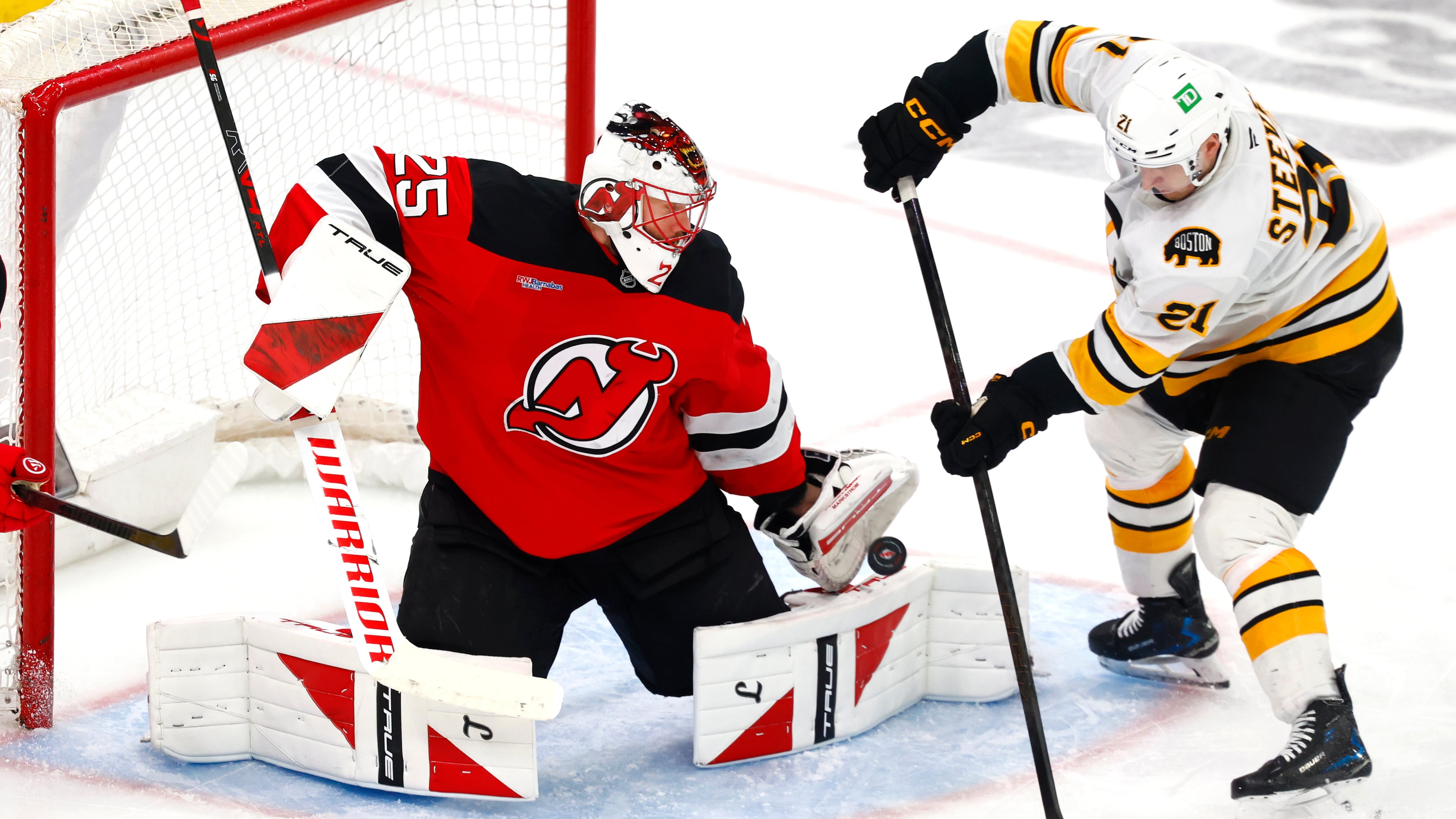 FILE - New Jersey Devils goaltender Jacob Markstrom (25) makes a save against Boston Bruins forward Alex Steeves (21) during the third period of an NHL hockey game, March 16, 2026, in Newark, N.J. (AP Photo/Noah K. Murray, File)