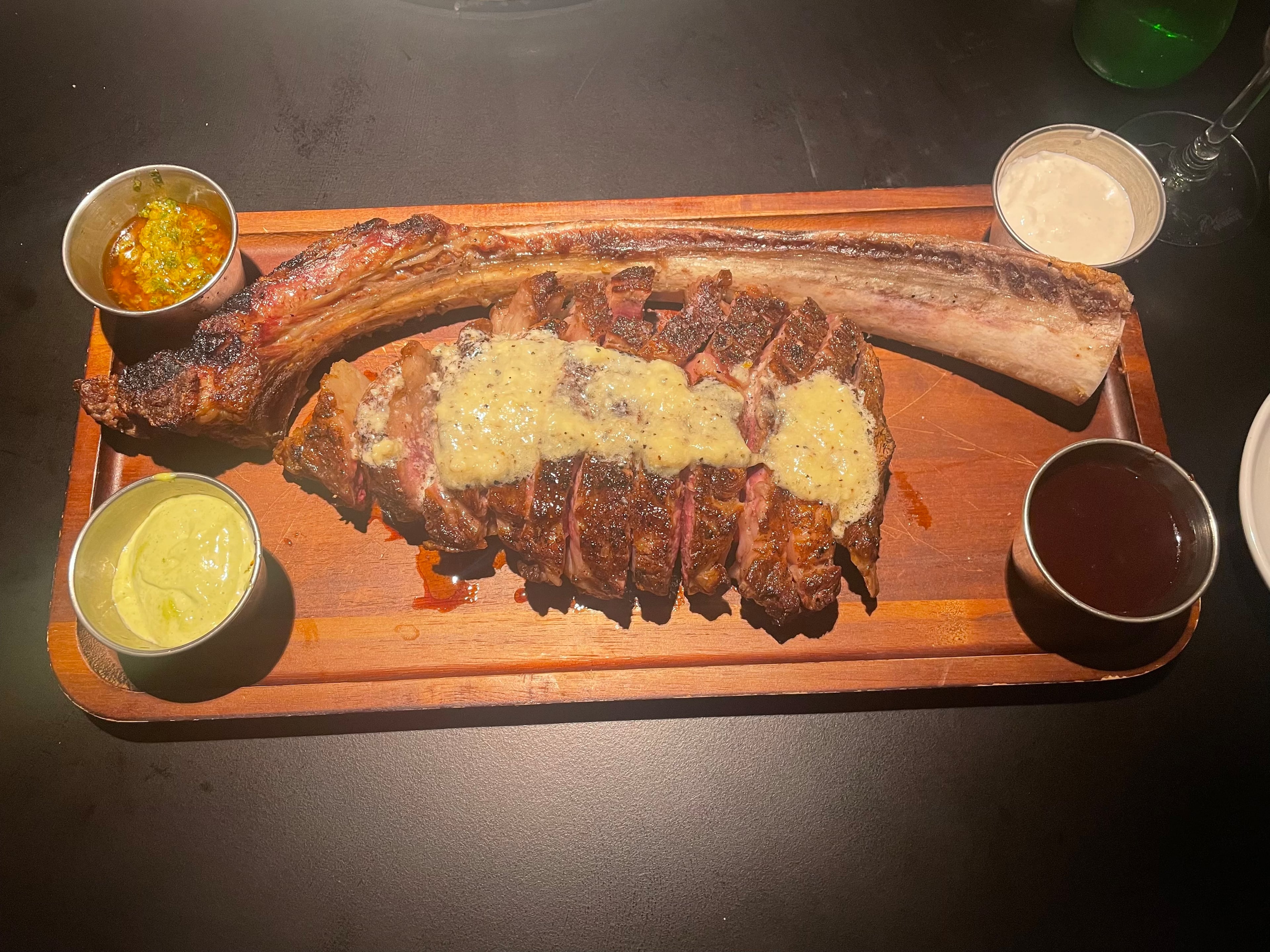 The wagyu tomahawk steak with melted truffle butter from Enzo Steakhouse and Bar in Fayetteville. (Justin Brown for the AJC)