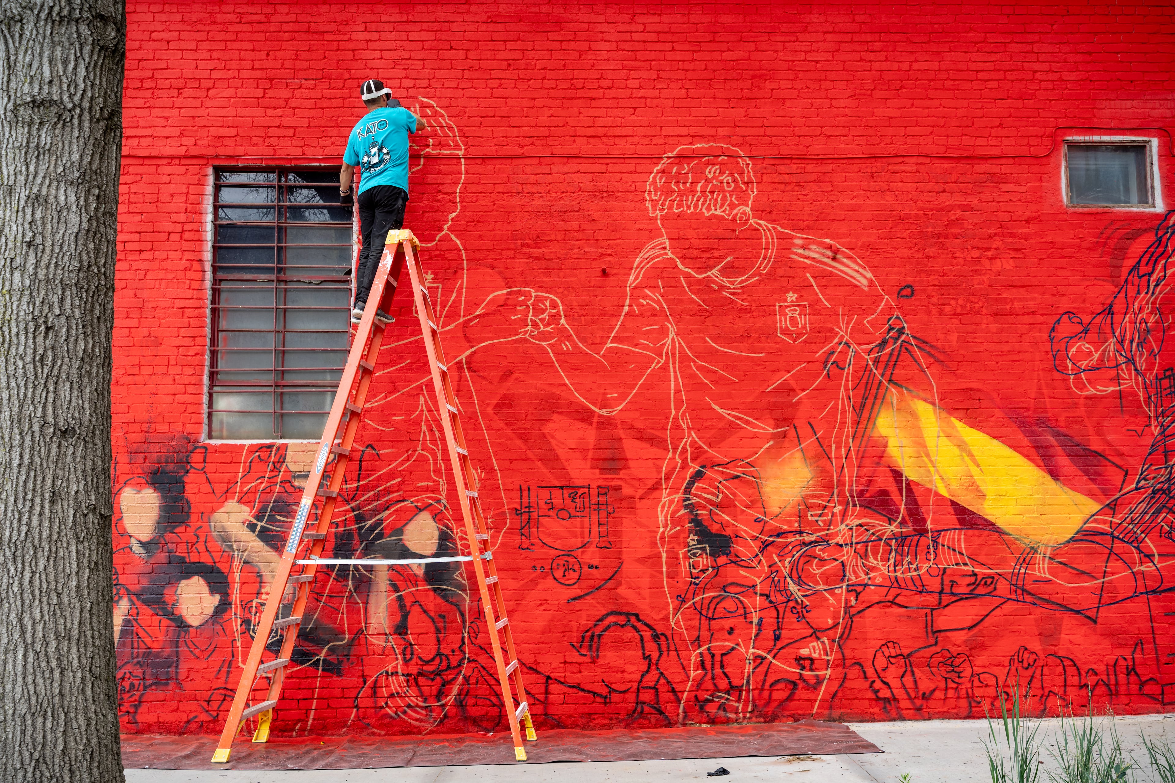 An Artist with Kato Art paints a mural along Broad Street on Monday, June 8, 2026. (Ben Hendren for the AJC)