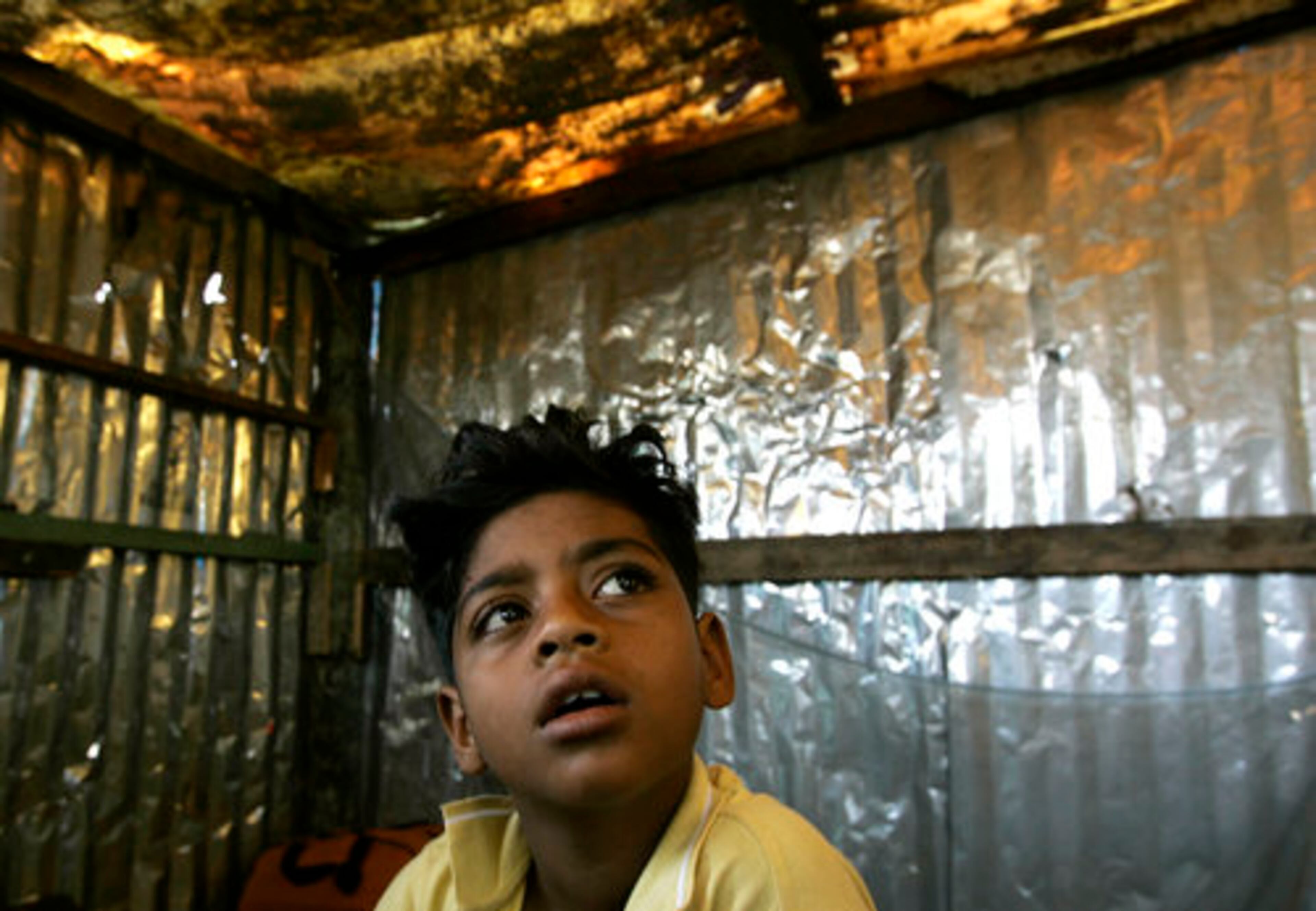 Azharuddin Mohammed Ismail look at his house in Mumbai. City authorities demolished the shacks around Ismail's home but left his standing. A bulldozer and about 30 men leveled about 18 homes in Garib Nagar, or "city of the poor" slum. They left another dozen partially standing.
