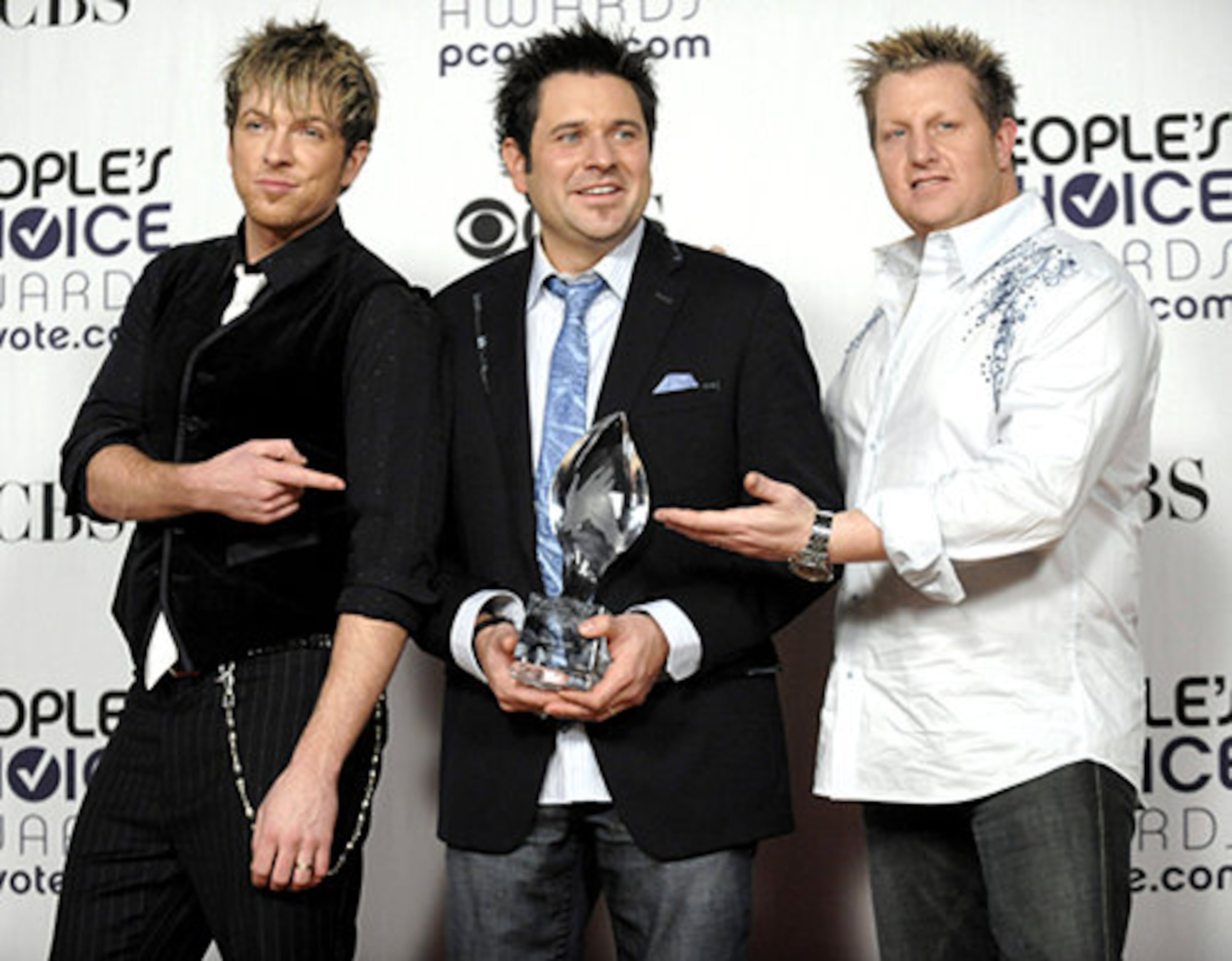 From left, Joe Don Rooney, Jay DeMarcus and Gary LeVox of Rascal Flatts pose backstage with the favorite group award.