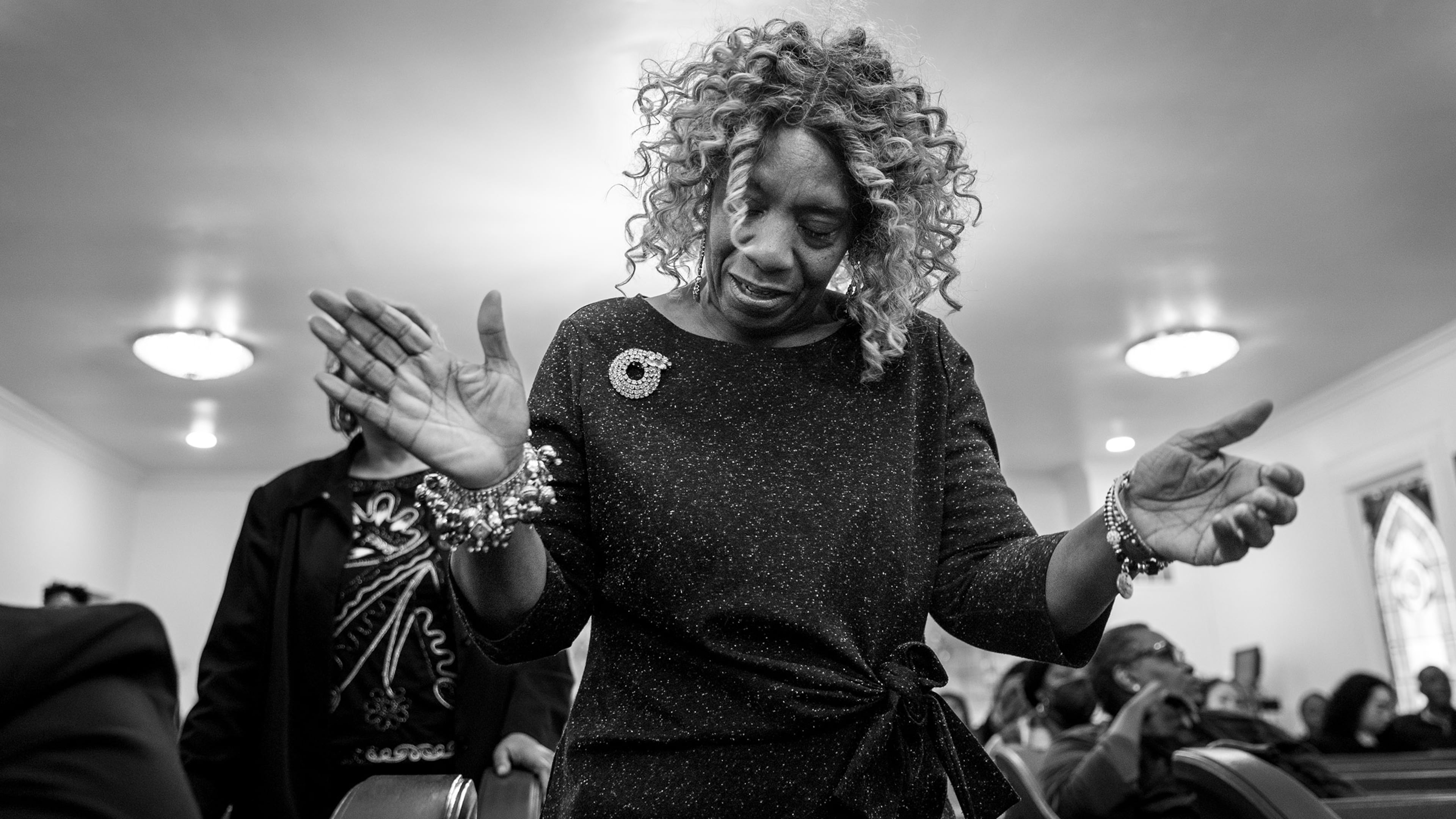 A mourner is swept up in gospel song during the homegoing of Marcus Johnson at Willie Watkins Funeral Home chapel on Nov. 11, 2023. (Arvin Temkar / arvin.temkar@ajc.com)