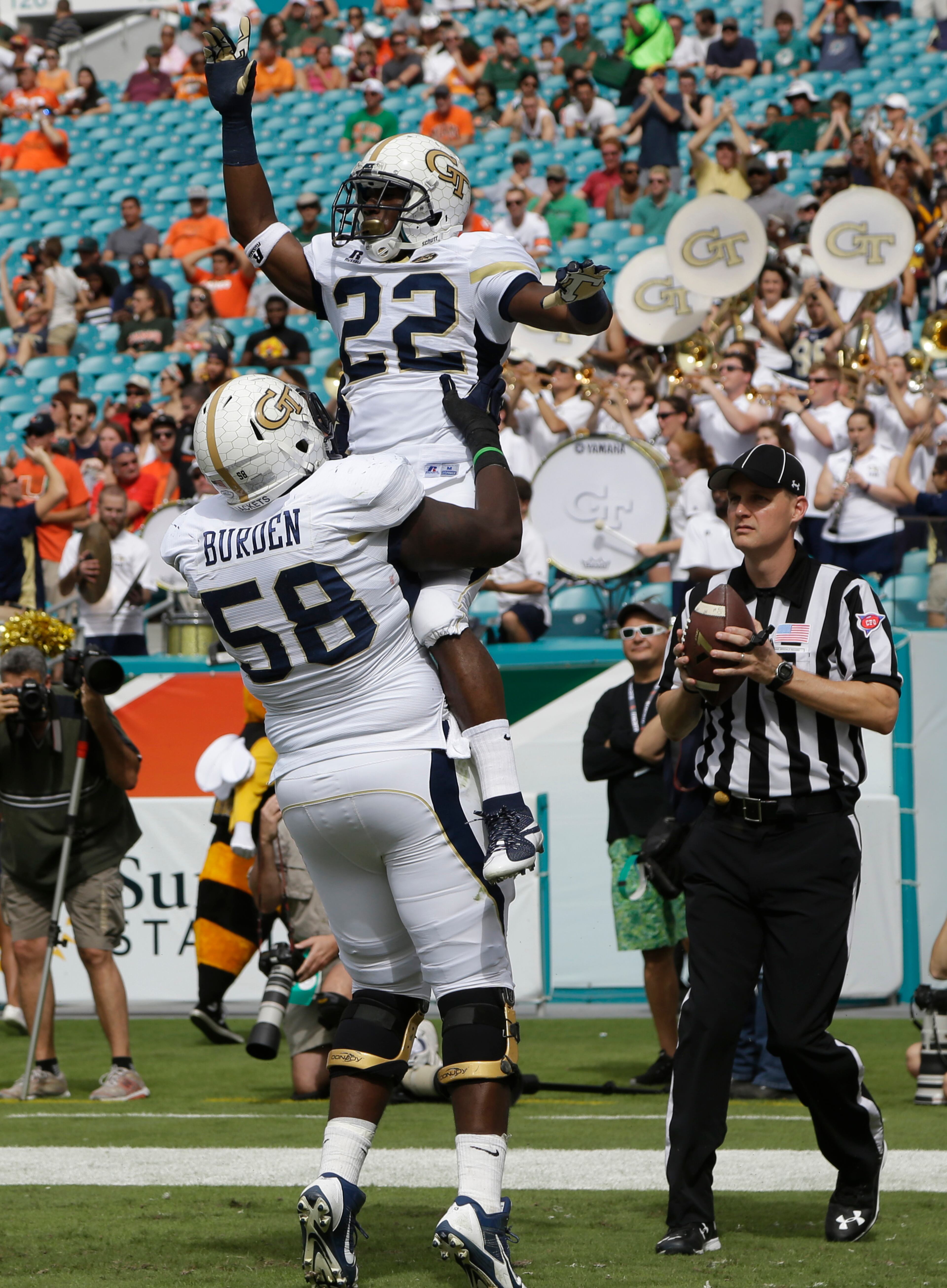 Georgia Tech running back Broderick Snoddy (22) celebrates with offensive lineman Freddie Burden (58) after scoring a touchdown during the first half of an NCAA college football game against Miami, Saturday, Nov. 21, 2015 in Miami Gardens, Fla. (AP Photo/Lynne Sladky)