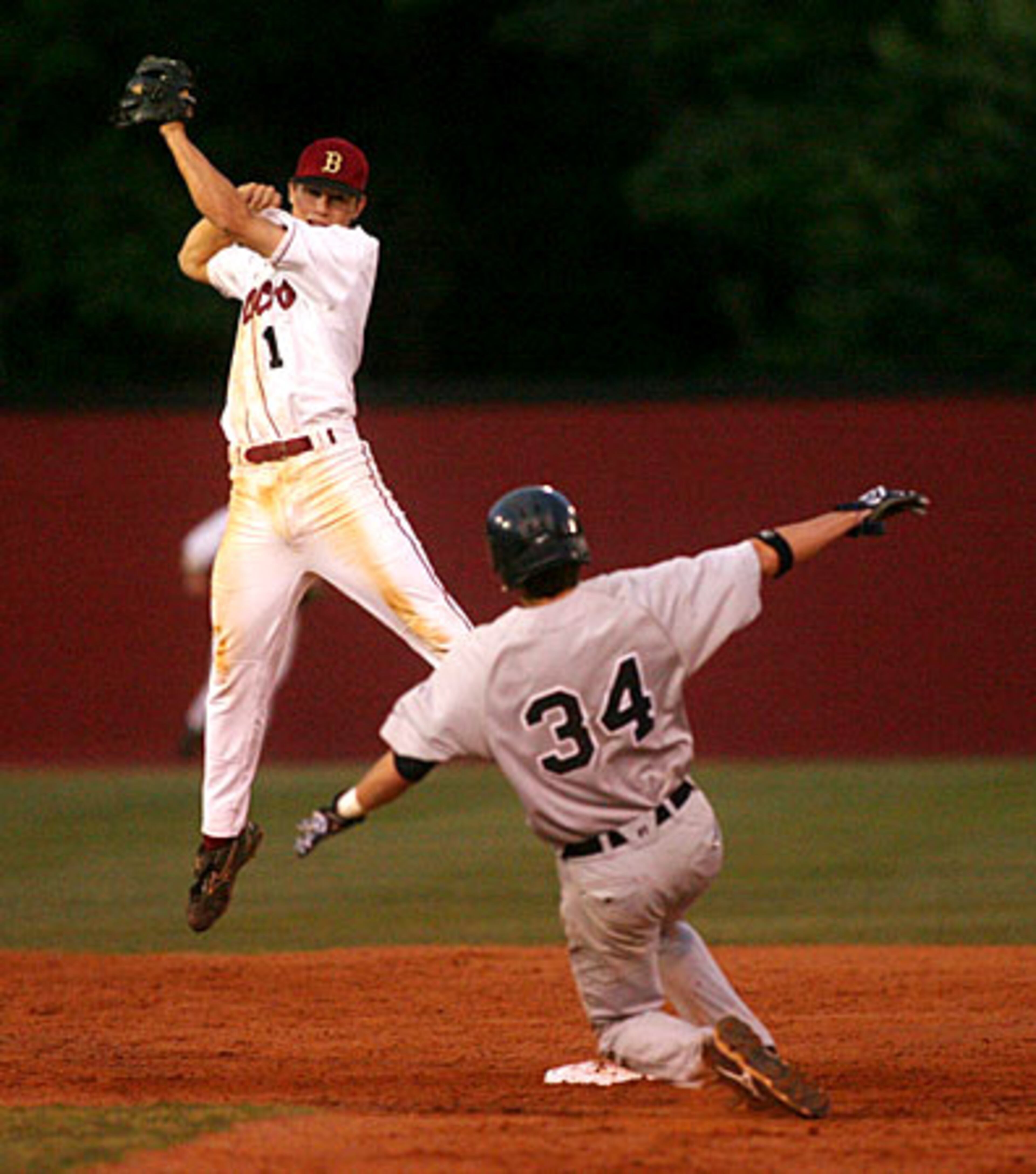 Brookwood's Jordan Erisman (1, left) leaps for the catch as Norcross' Roach (34) slides into second.