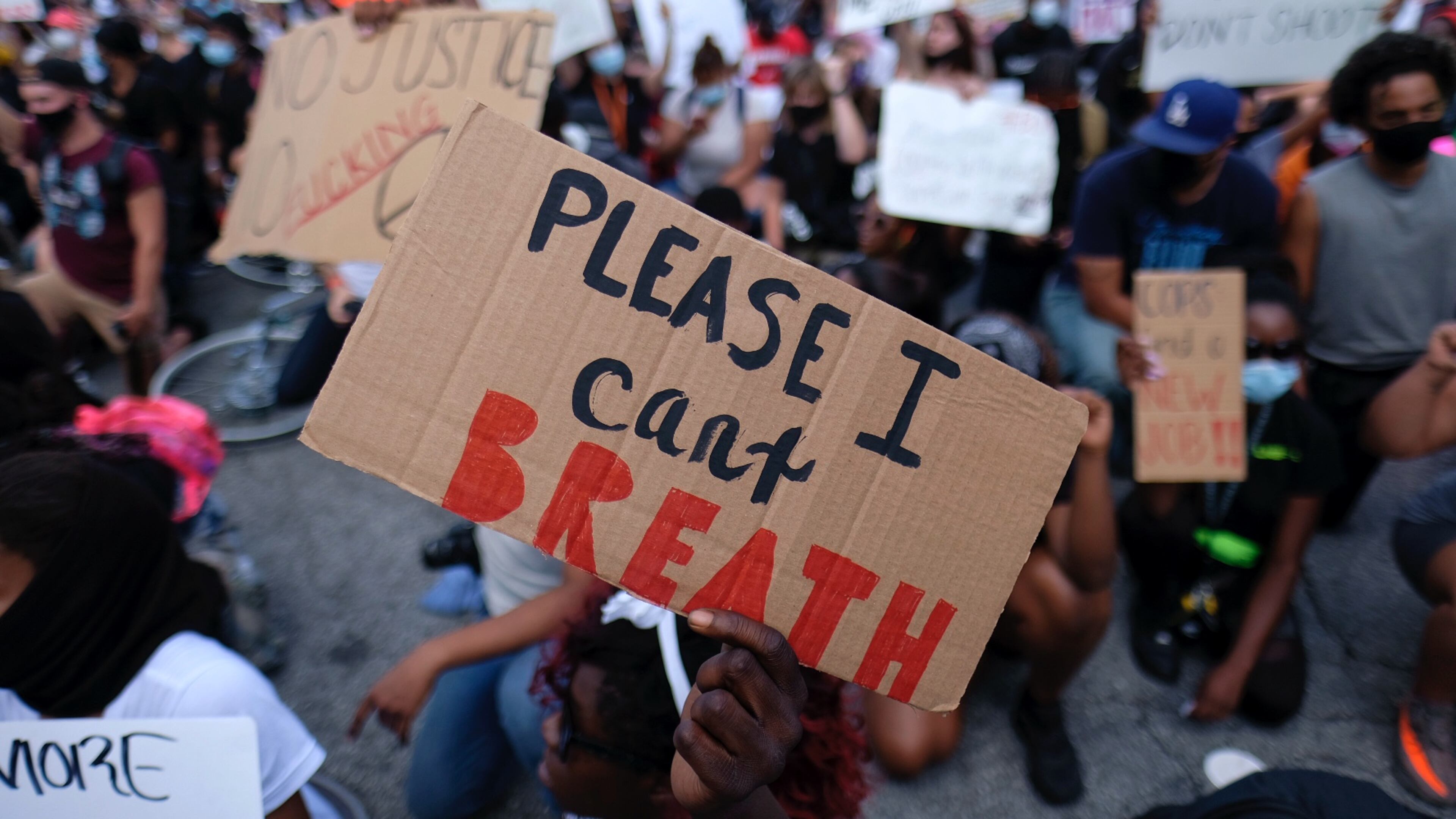Protesters hold signs downtown on Monday. (Ben Gray for the Atlanta Journal Constitution)