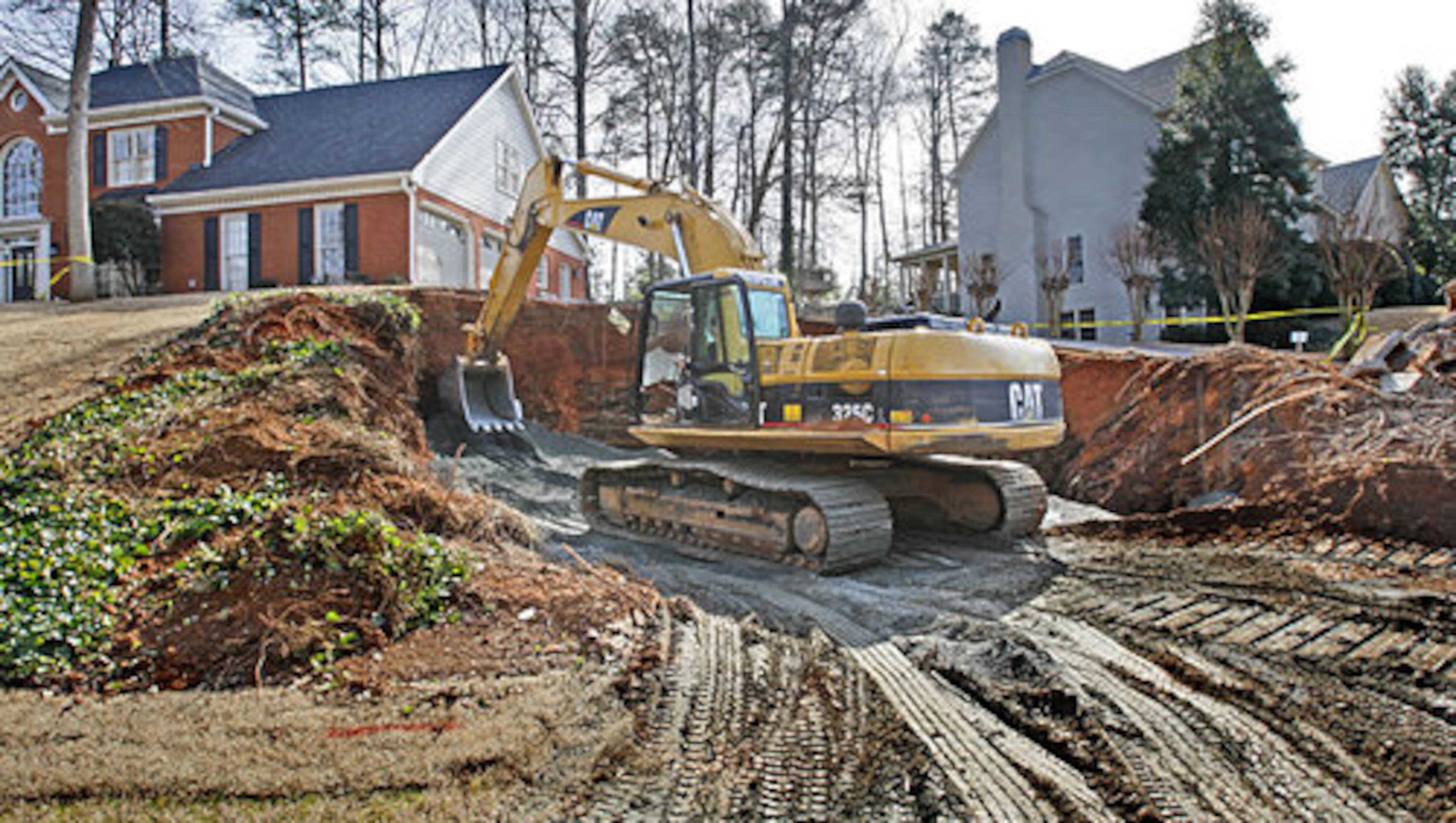 Wayne Marcinko of G.E.M. Contractors uses a backhoe to pack the A-10 manufactured granite in for the base that will be followed by dirt.