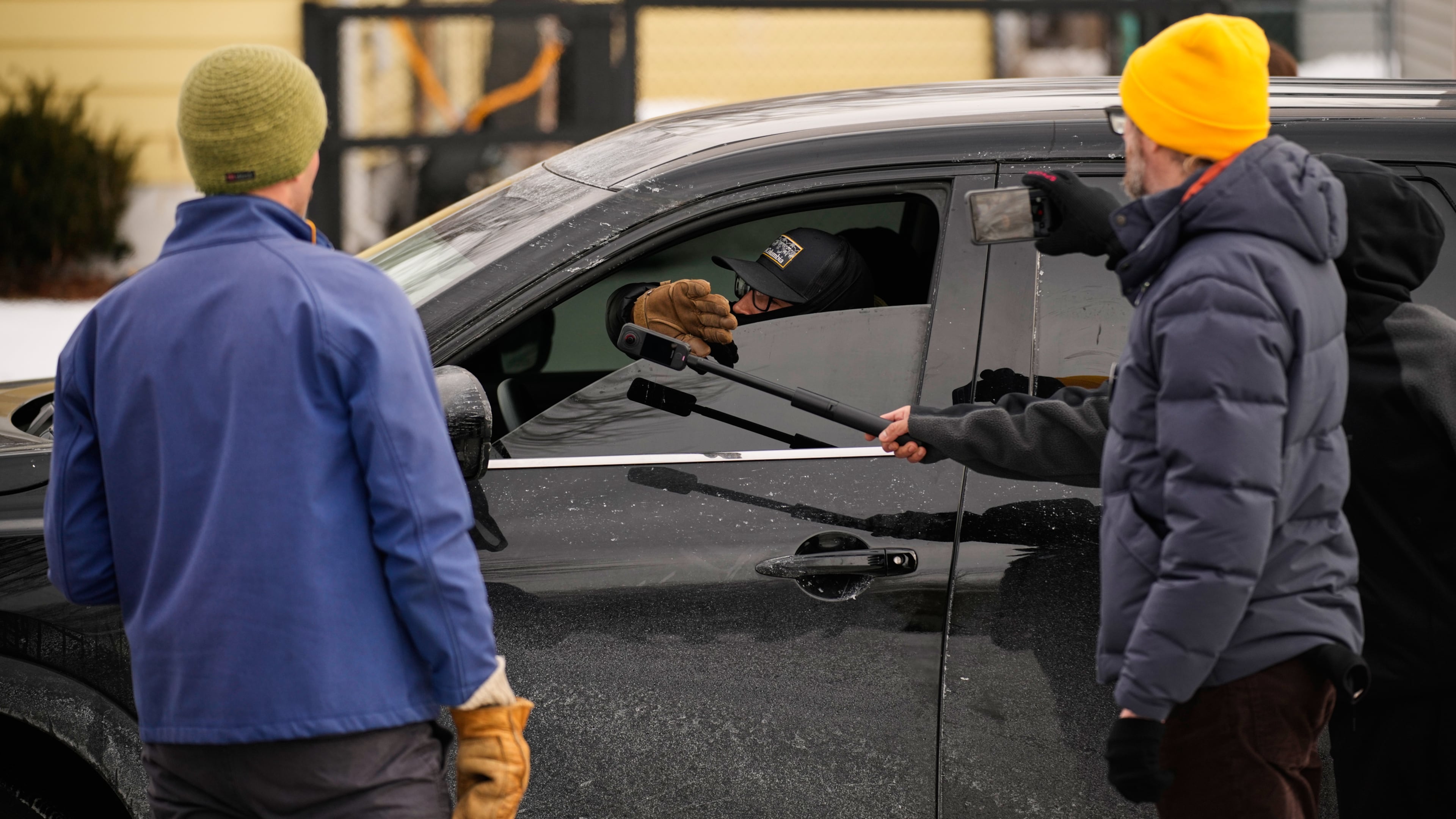 Bystanders film a federal immigration officer in their car Sunday, Jan. 11, 2026, in Minneapolis. (AP Photo/John Locher)