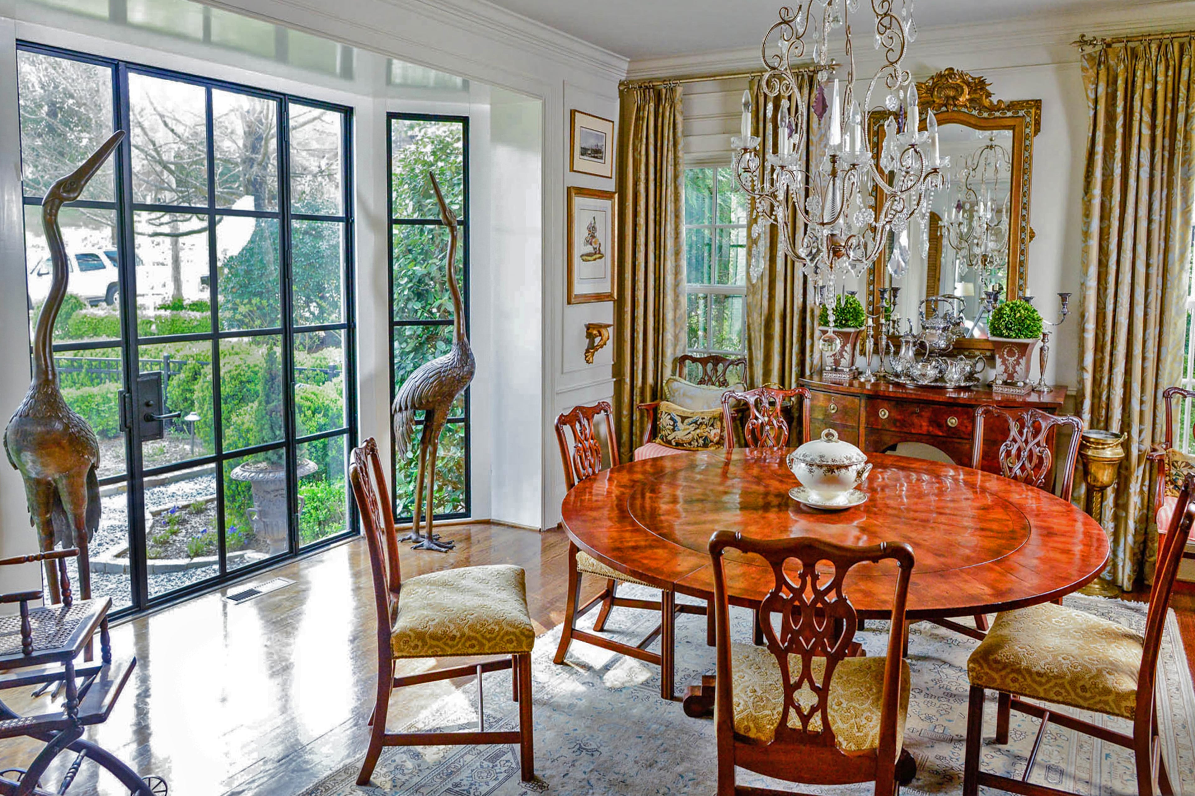 A French chandelier from Scott Antique Markets hangs above the dining room table in Dina Woodruff's Atlanta home. She said it was found in an old hotel and was coated dark brown from smoke. A few of the crystals around the middle of the open-framed design are purple. The French mirror over the buffet was found at Scott Antique Markets.