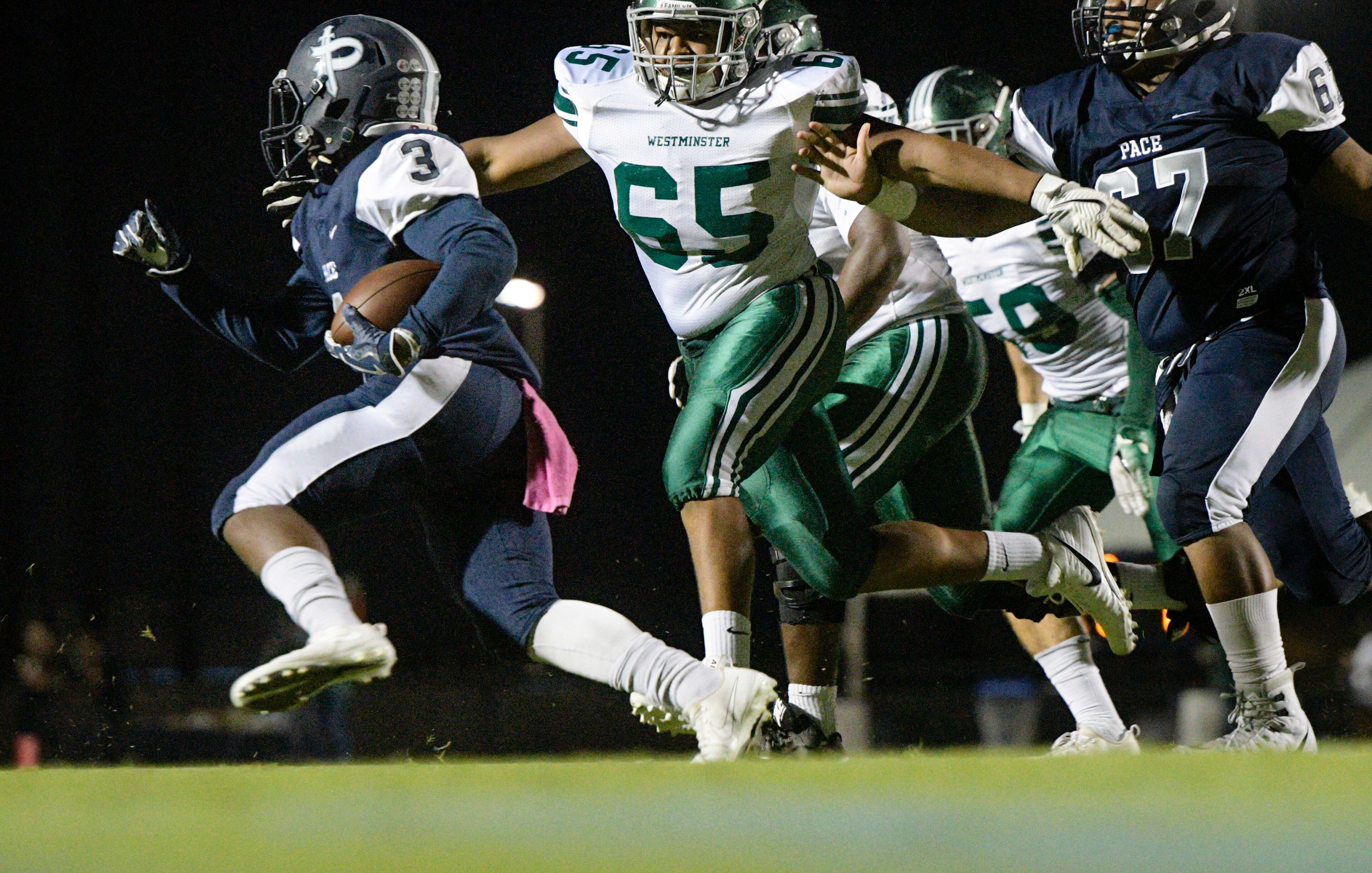 Pace Academy's Emon Hill jr. rushes as Westminster DT Jamel Streater (65) pursues during their high school football game Oct. 6, 2017, in Atlanta. (Special for the Atlanta Journal Constitution/John Amis)