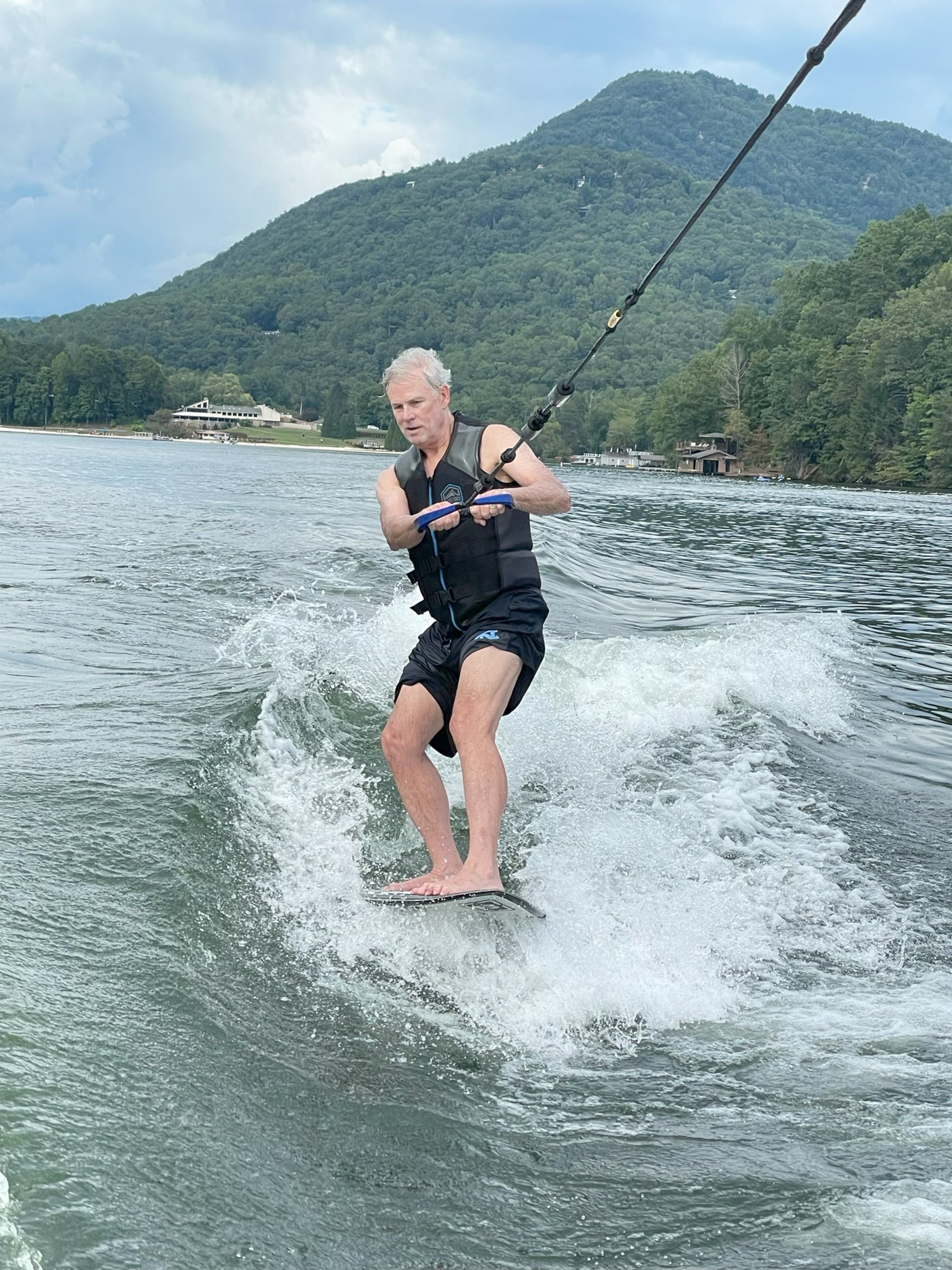 David Stockton, a pancreatic cancer patient, wakeboards on Lake Lure. He recently began treatment with a new drug, daraxonrasib. (Courtesy of Thatcher Townsend)