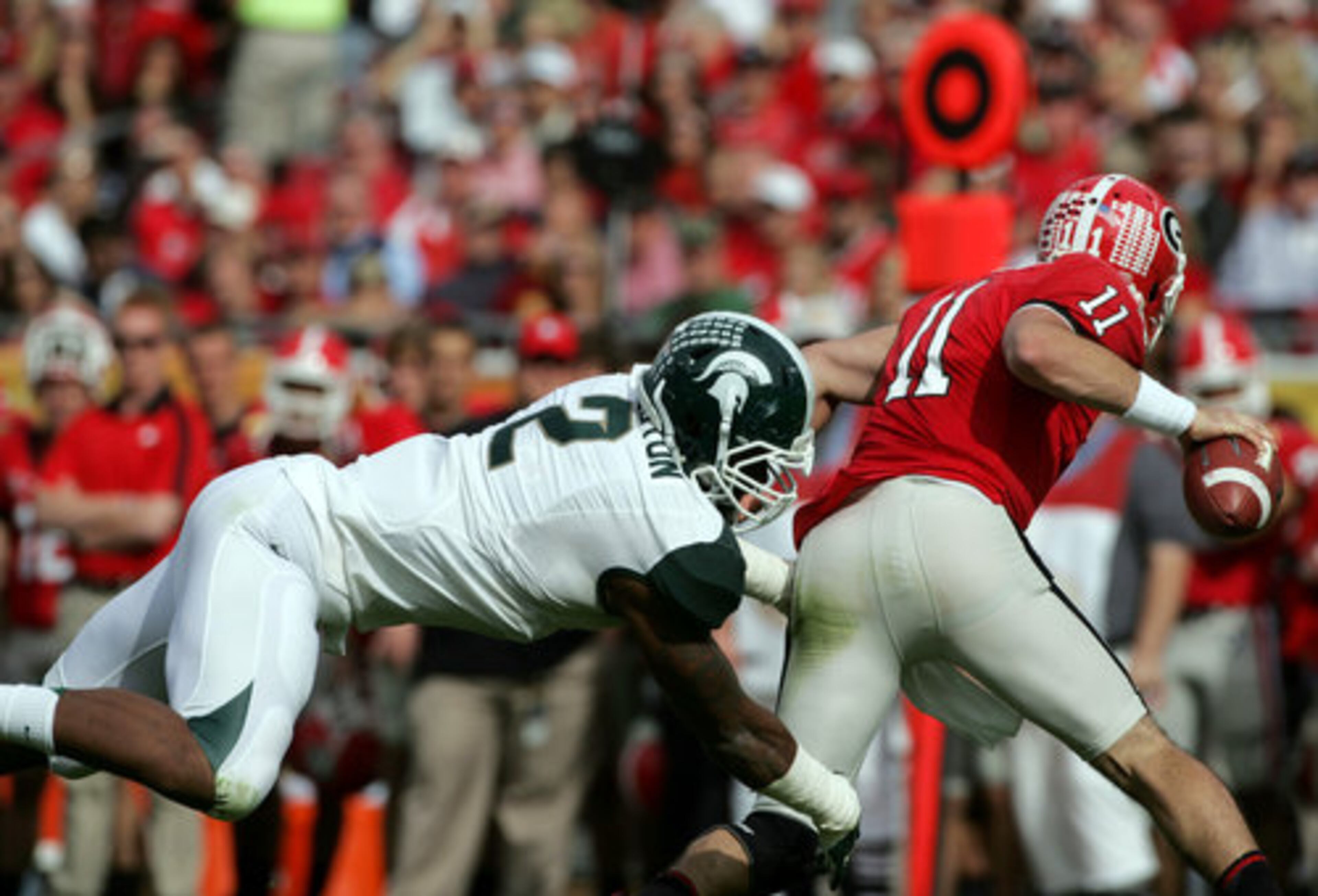 Michigan State University's William Gholston, left, sacks University of Georgia quarterback Aaron Murray for a loss during the second quarter.