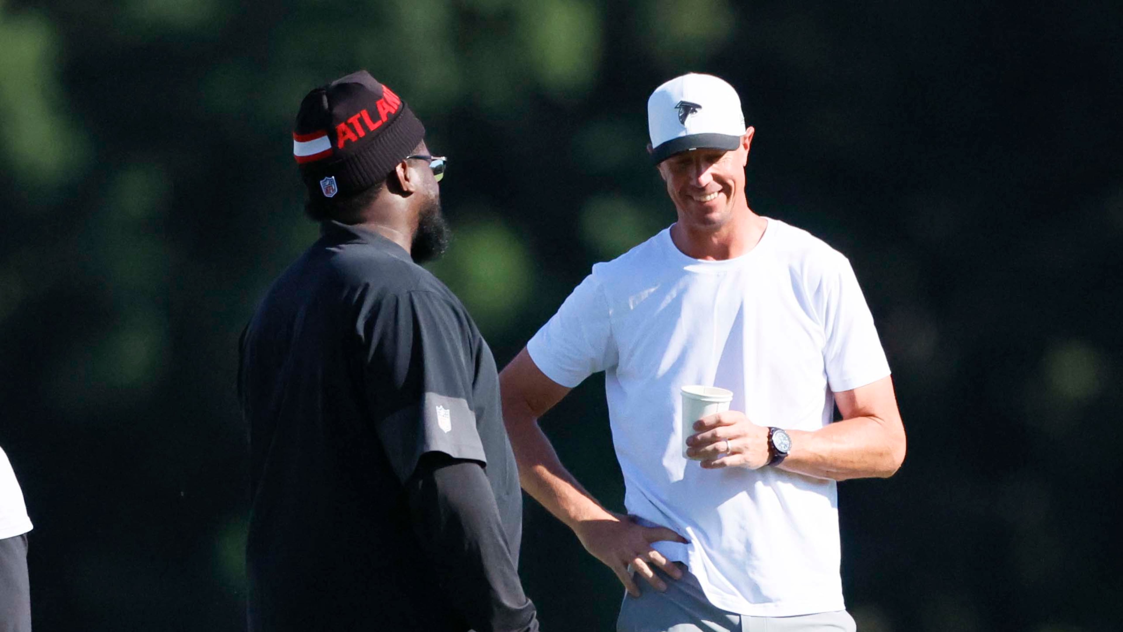 Former Atlanta Falcons quarterback Matt Ryan speaks with Falcons’ defensive line coach Nate Ollie during training camp at the Falcons Practice Facility on Sunday, July 27, in Flowery Branch, Ga. Falcons radio analyst Dave Archer thinks Ryan can help the team, particularly with young and developing quarterback Michael Penix Jr. (Miguel Martinez/AJC)