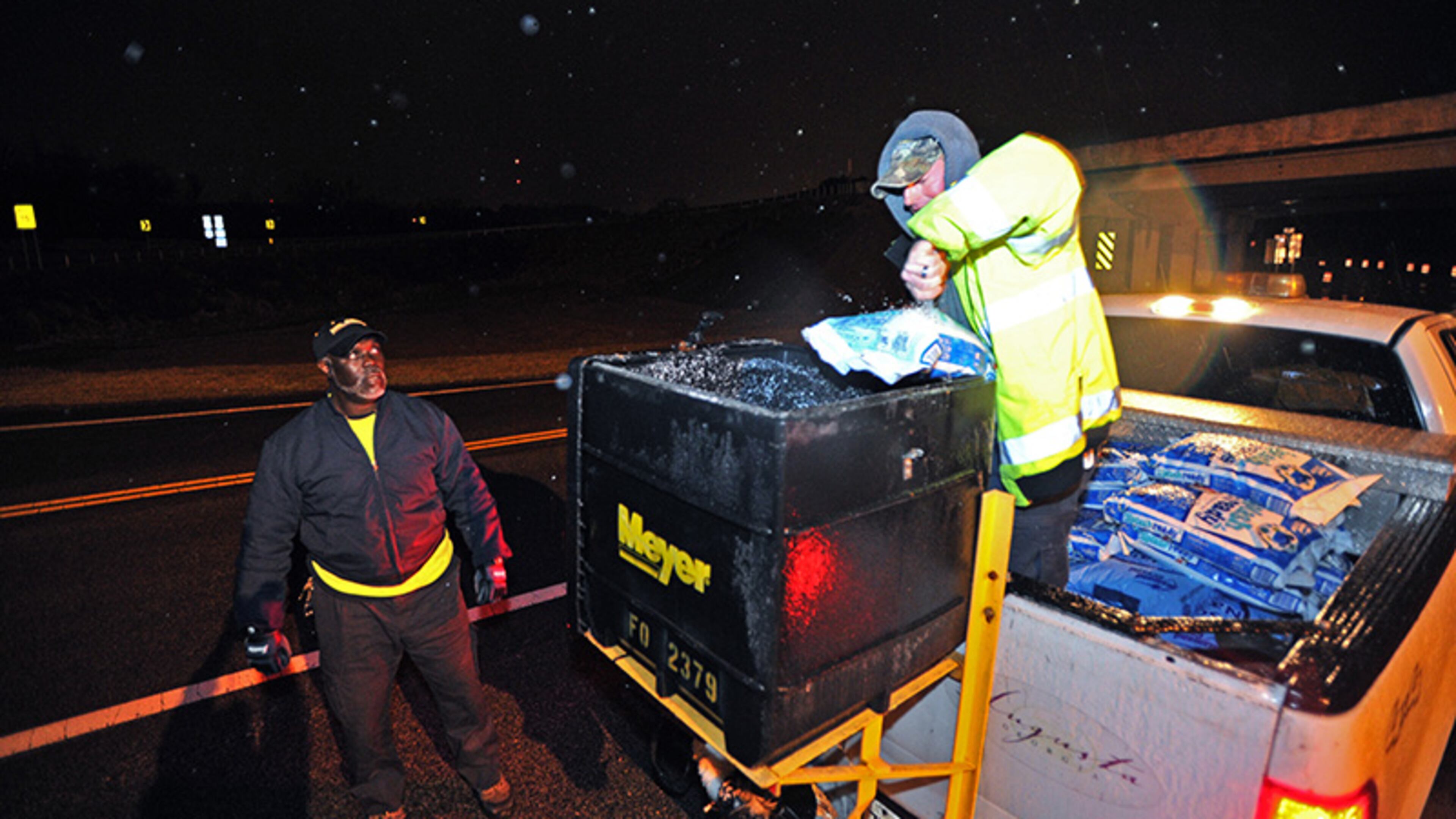 Richmond County workers John Johnson (left) and David Wilkey prepare to spread salt and sand on 5th Street in downtown Augusta on Wednesday, February 12, 2014. Georgia's so-called Garden City is preparing to be Ice City by morning, with thousands of homes losing power and felled trees shutting down roadways.