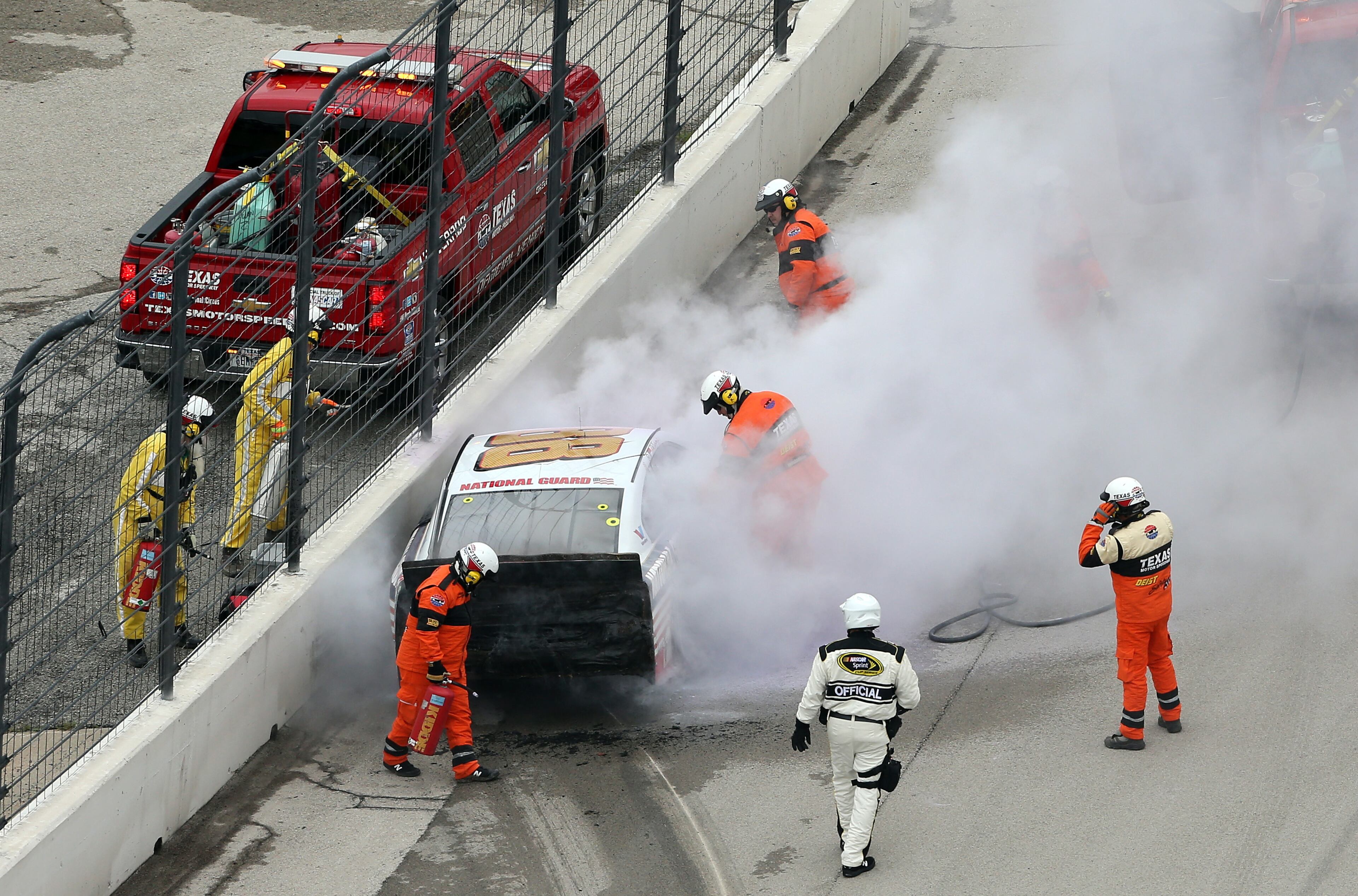 Safety crew members tend to the car of Dale Earnhardt Jr., driver of the #88 National Guard Chevrolet, after an incident during the NASCAR Sprint Cup Series Duck Commander 500 at Texas Motor Speedway on April 7, 2014 in Fort Worth, Texas. (Photo by Nick Laham/Getty Images for Texas Motor Speedway)