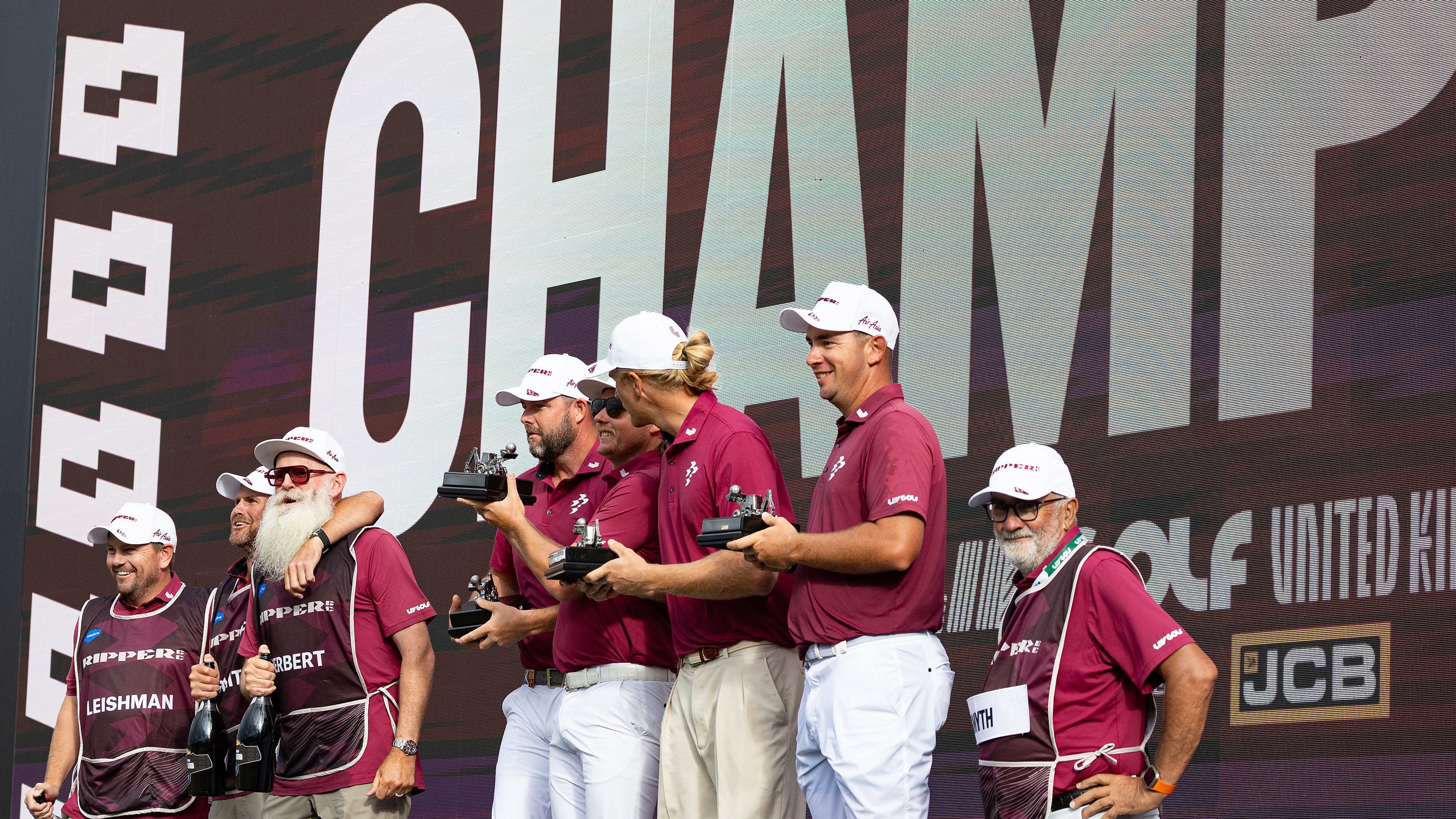 Team champions captain Cameron Smith, Marc Leishman, Lucas Herbert and Travis Smyth, of Ripper GC, and their caddies celebrate onstage after their first-place win following the final round of the LIV Golf United Kingdom golf tournament Sunday, July 26, 2026, in Rocester, England. (Jon Ferrey/LIV Golf via AP)