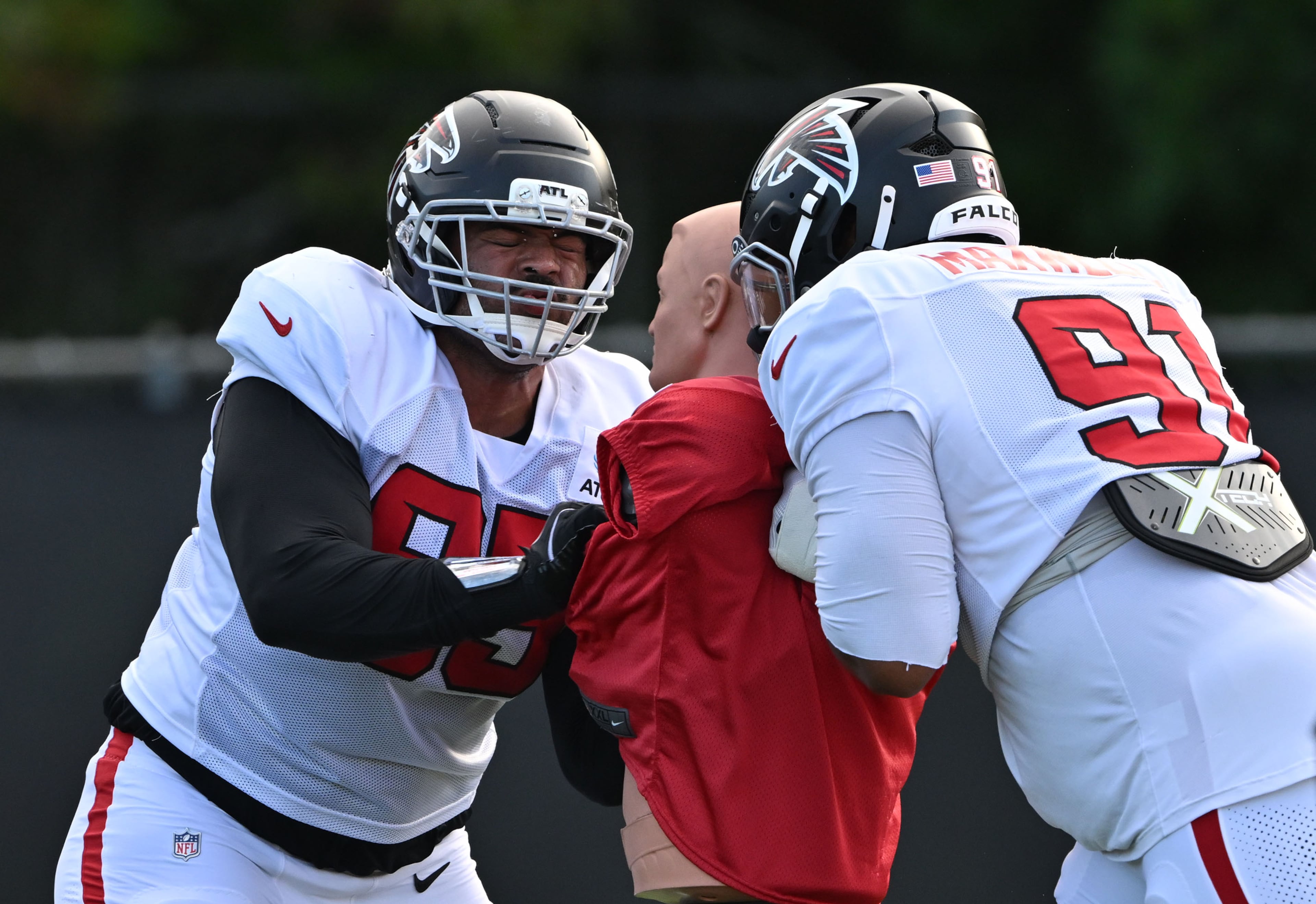 Falcons defensive tackles Marlon Tuipulotu (left) and Devonnsha Maxwell run a drill during "Saturday Night Lights" practice Saturday, Aug. 8, 2026, at Lanier High School in Sugar Hill. (Hyosub Shin/AJC)
