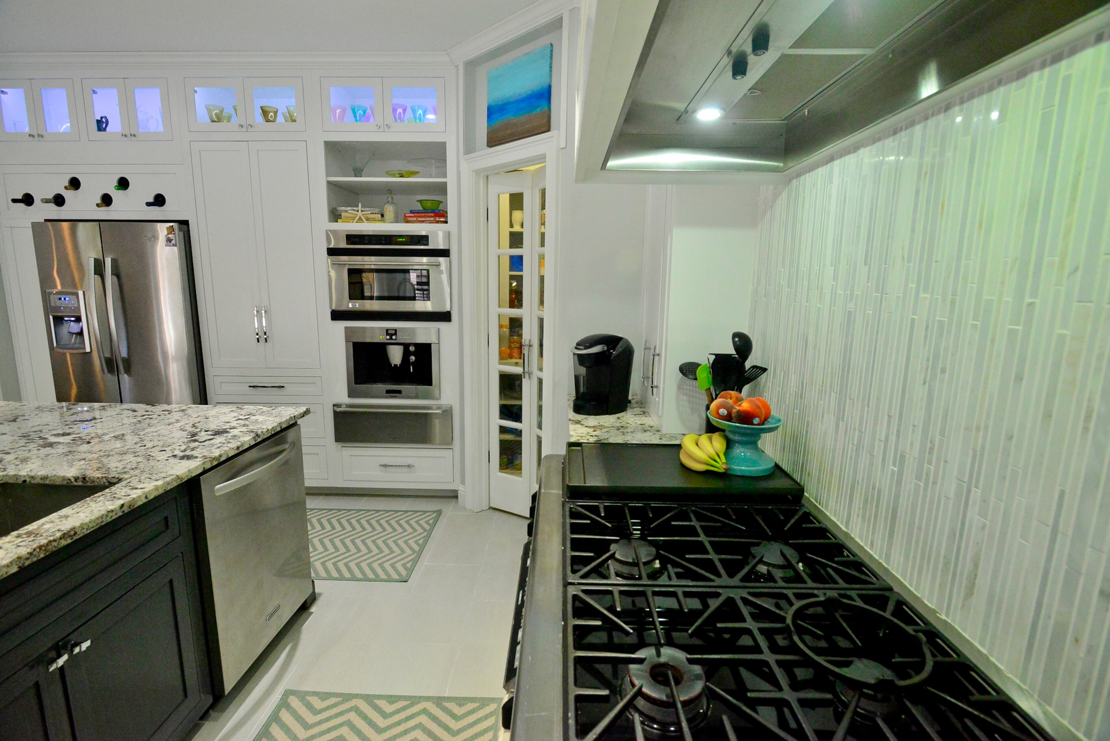 The white cabinets and illuminated display space immediately appealed to the homeowners in the kitchen, which has luxury Bosch and Dacor appliances and built-in extras including a coffee maker, warming drawer, icemaker and wine refrigerator.