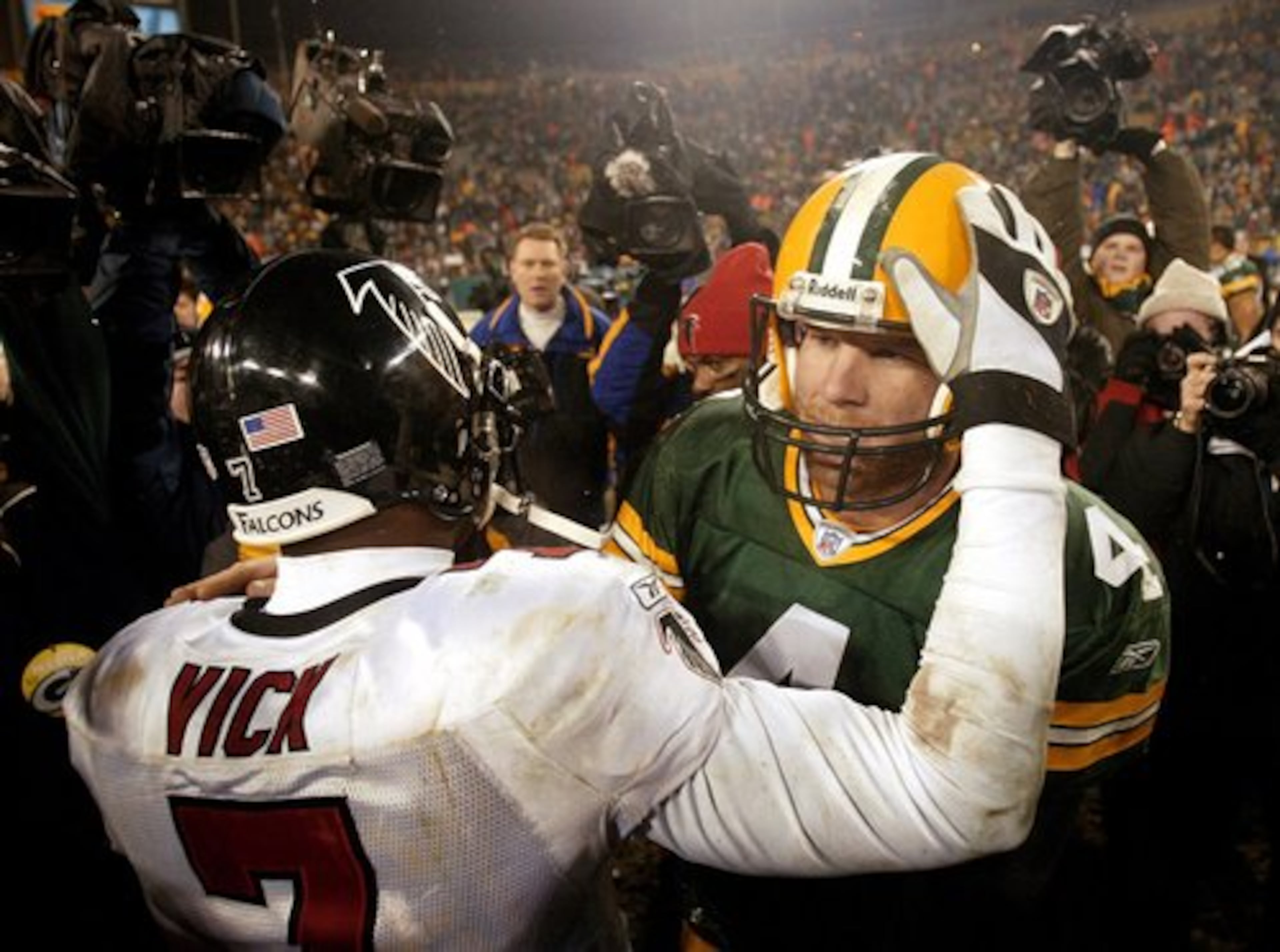 Falcons quarterback Michael Vick embraces Green Bay quarterback Brett Favre following Atlanta's 27-7 NFC Wildcard game win. Eight years later, Favre struggled in Minnestoa while Vick got Philidelpha to the playoffs. The Eagles lost last week to the Packers, 21-16.