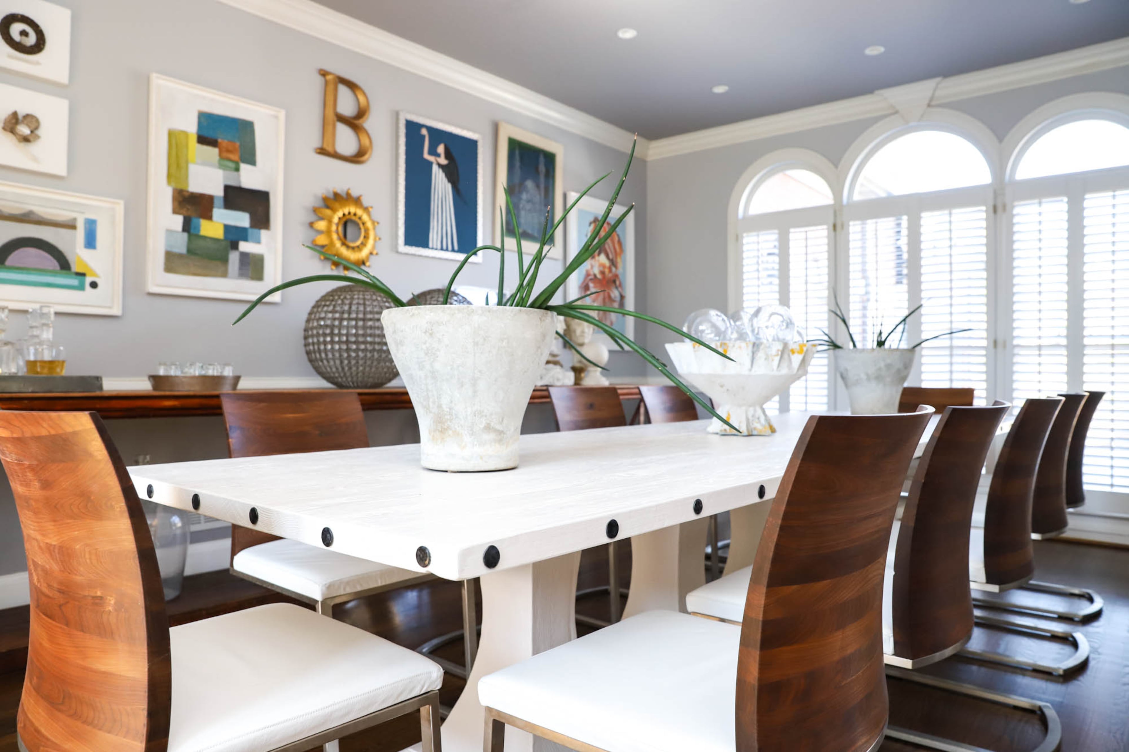 A custom dining room table and black walnut chairs from etúHome make the centerpiece of Joe and Stacy’s dining room. “You can sit at the table forever and keep the evening going because it’s a comfortable seat,” said Stacy. Willy Guhl planters from France line the table. Text by Shannon Dominy/Photo by Reynolds Rogers
