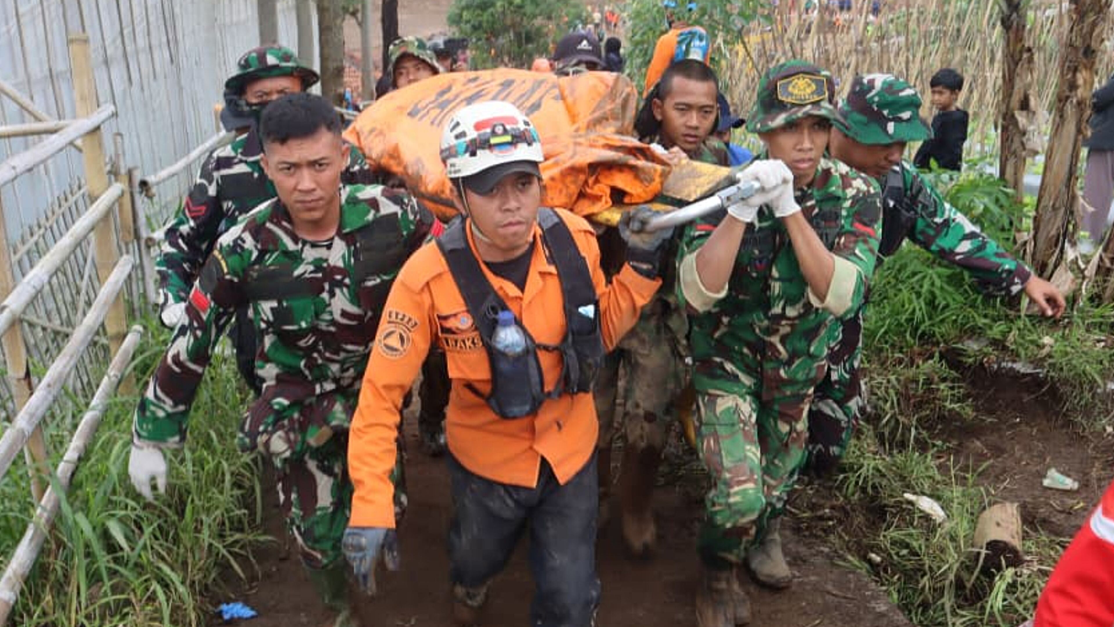 In this photo released by Indonesia's National Disaster Management Agency (BNPB) rescuers carry the body of a victim of landslide at Pasir Langu village after a landslide, in West Bandung district of West Java province, Indonesia, Monday, Jan. 26, 2026. (BNPB via AP)