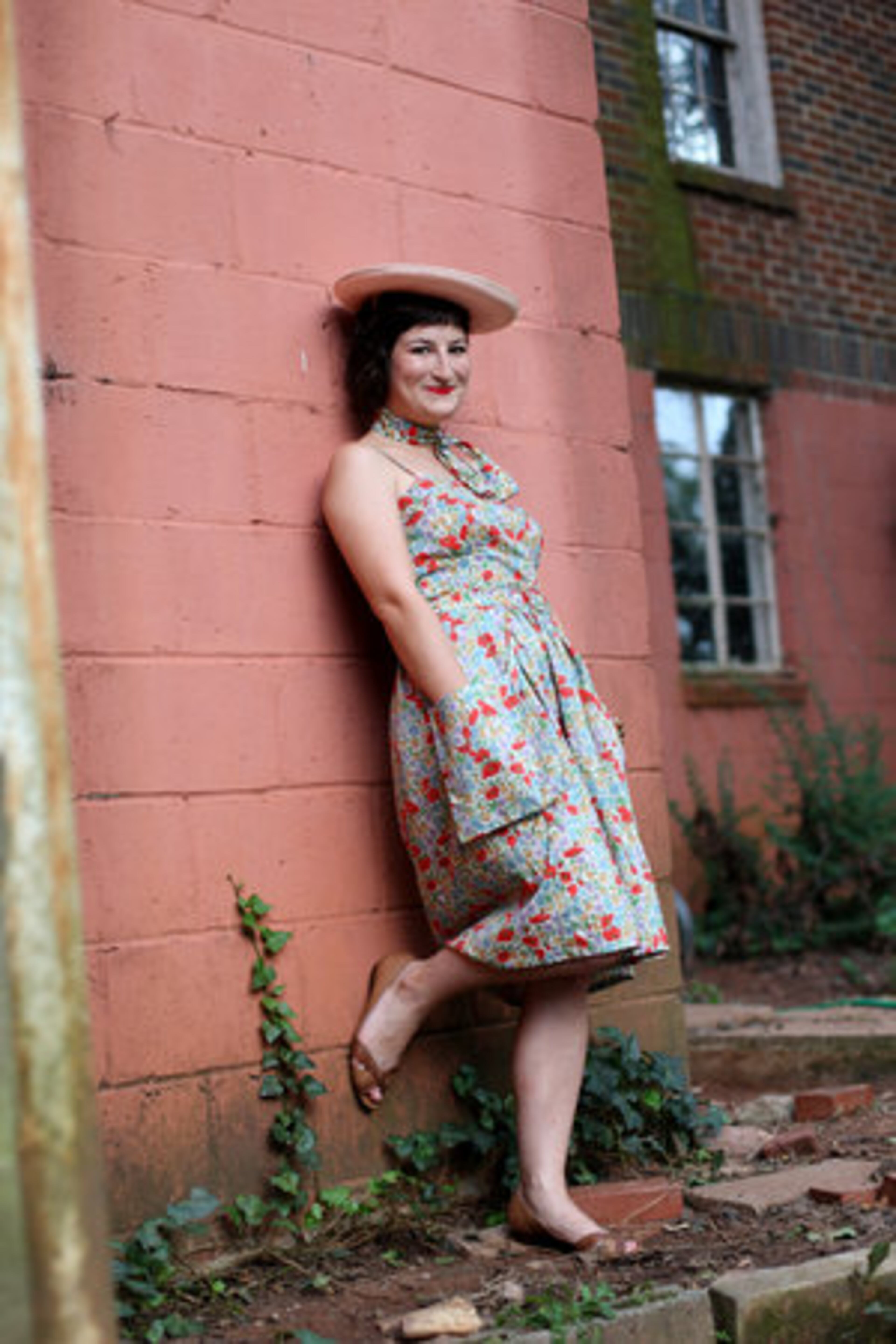 Leila Regan-Porter wears a 1970's style dress that she made from vintage liberty fabric. She accessorizes with peep toe flats by Nicole, a bracelet and earrings from J.Crew and a vintage hat purchased on Etsy.