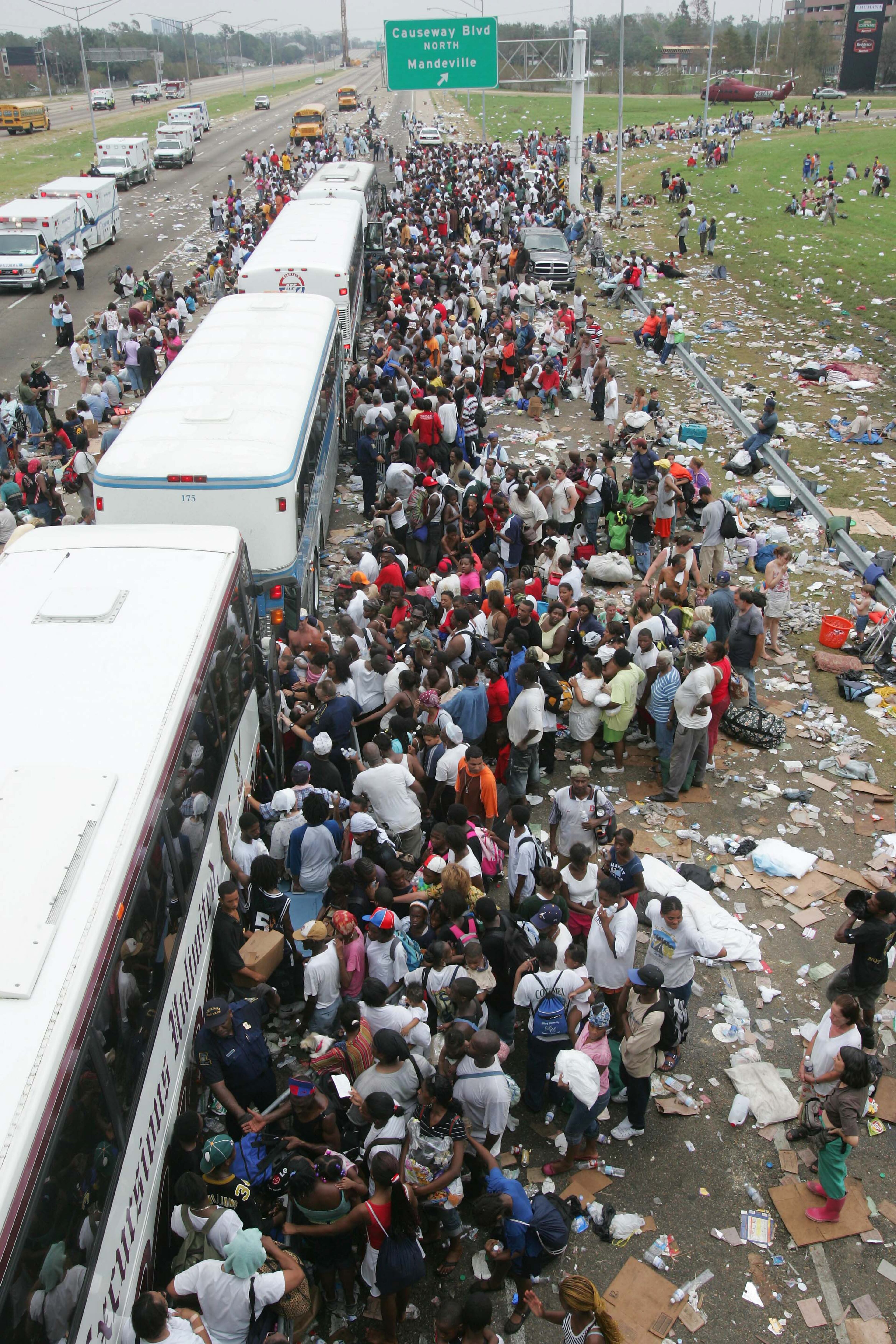 Thousands of New Orleans residents gather at a evacuation staging area along Interstate-10 in Metarie, La., on Thursday, Sept. 1, 2005. The residents were either evacuated by air or walked to the Interstate to escape the city still besieged by flooding and no electricity. (AP Photo/Dave Martin)