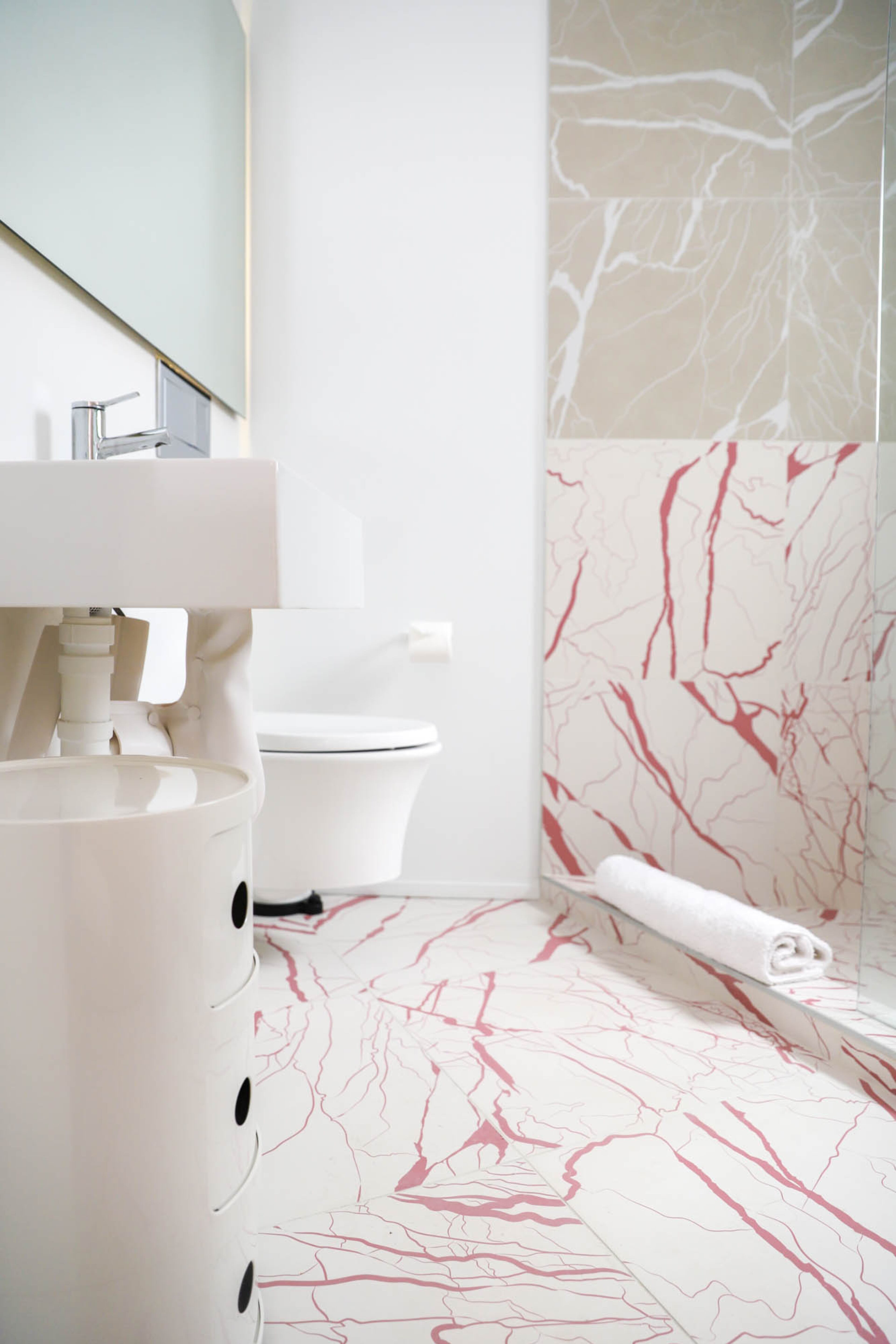 Ceramic tiles from Ornamenta's Artwork collection, in magenta and pearl, are used in the bathroom. Kartell's Componibili triple storage cabinet was designed by Anna Castelli Ferrieri and purchased from Switch Modern. Text by Lori Johnston/Fast Copy News Service. Photo by Reynolds Rogers/Fast Copy News Service.