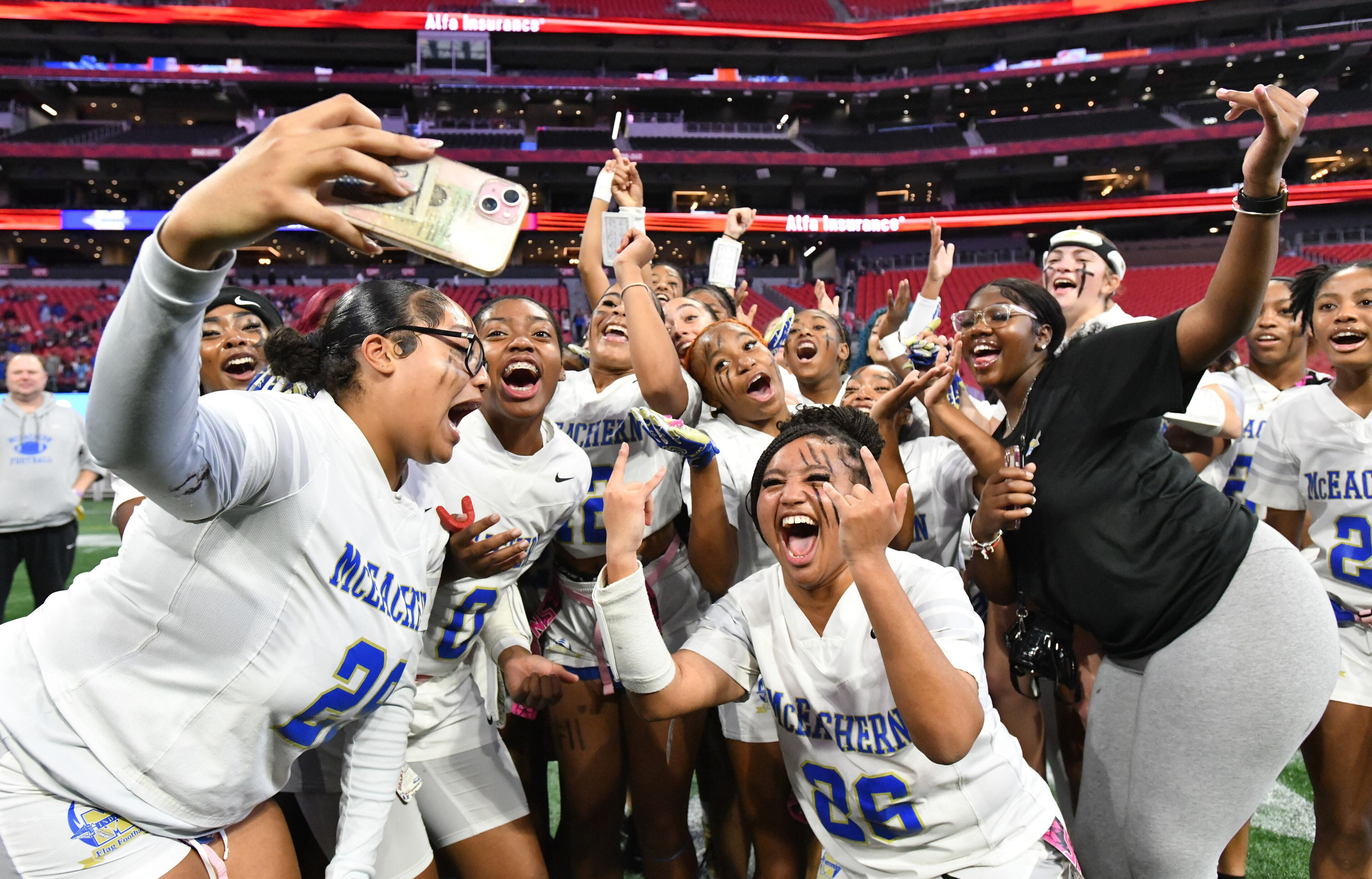 McEachern players celebrate their victory over Lambert in GHSA Division 4 Flag Football State Championship game at Mercedes-Benz Stadium, Wednesday, December 18, 2024, in Atlanta. McEachern won 26-6 over Lambert. (Hyosub Shin / AJC)
