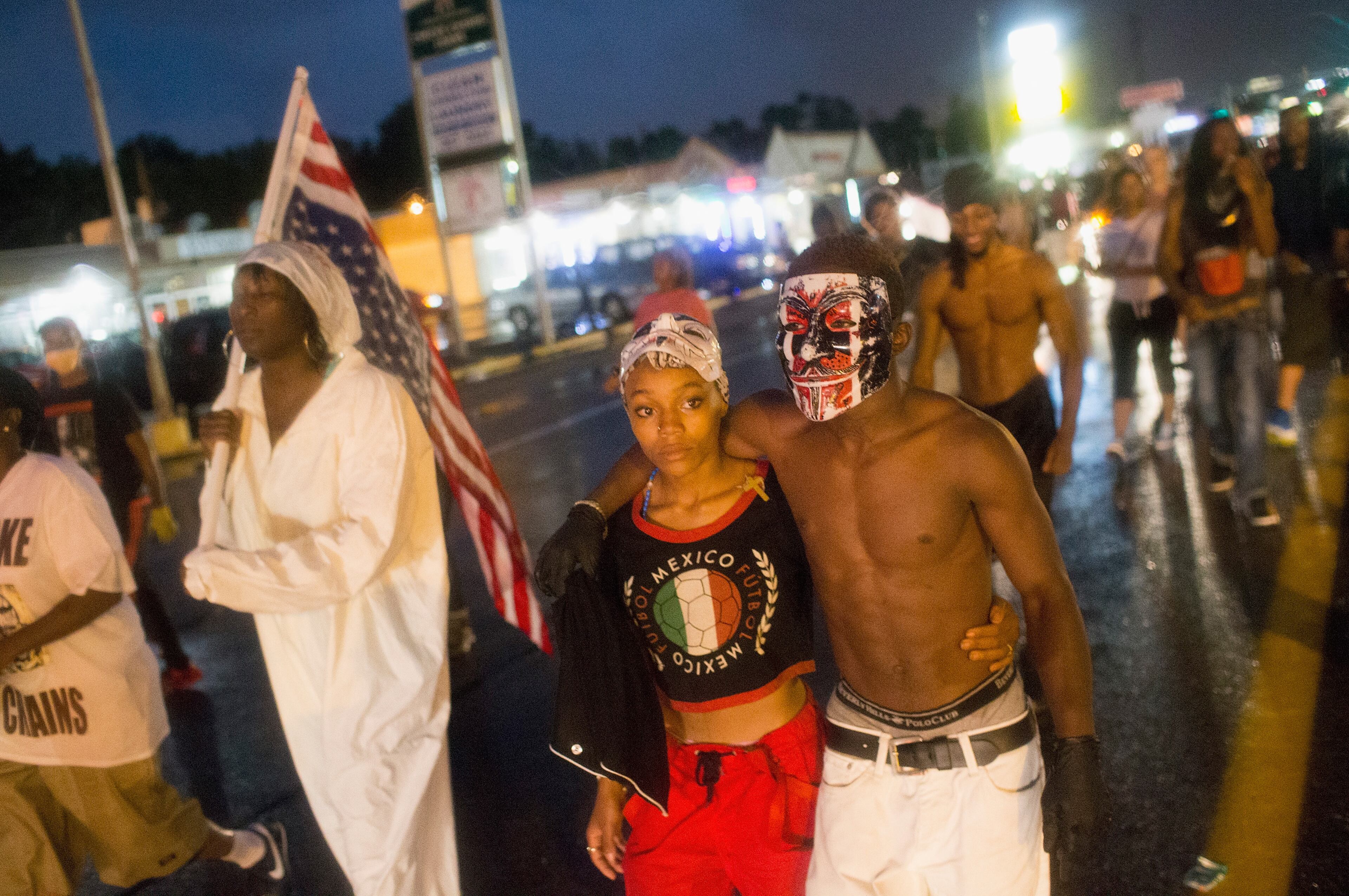 FERGUSON, MO - AUGUST 09: Demonstrators, marking the one-year anniversary of the shooting of Michael Brown, march along West Florrisant Street on August 9, 2015 in Ferguson, Missouri. There are reports that two people were shot when gun fire broke out during protests later in the evening. Brown was shot and killed by a Ferguson police officer on August 9, 2014. His death sparked months of sometimes violent protests in Ferguson and drew nationwide focus on police treatment of black offenders. (Photo by Scott Olson/Getty Images)