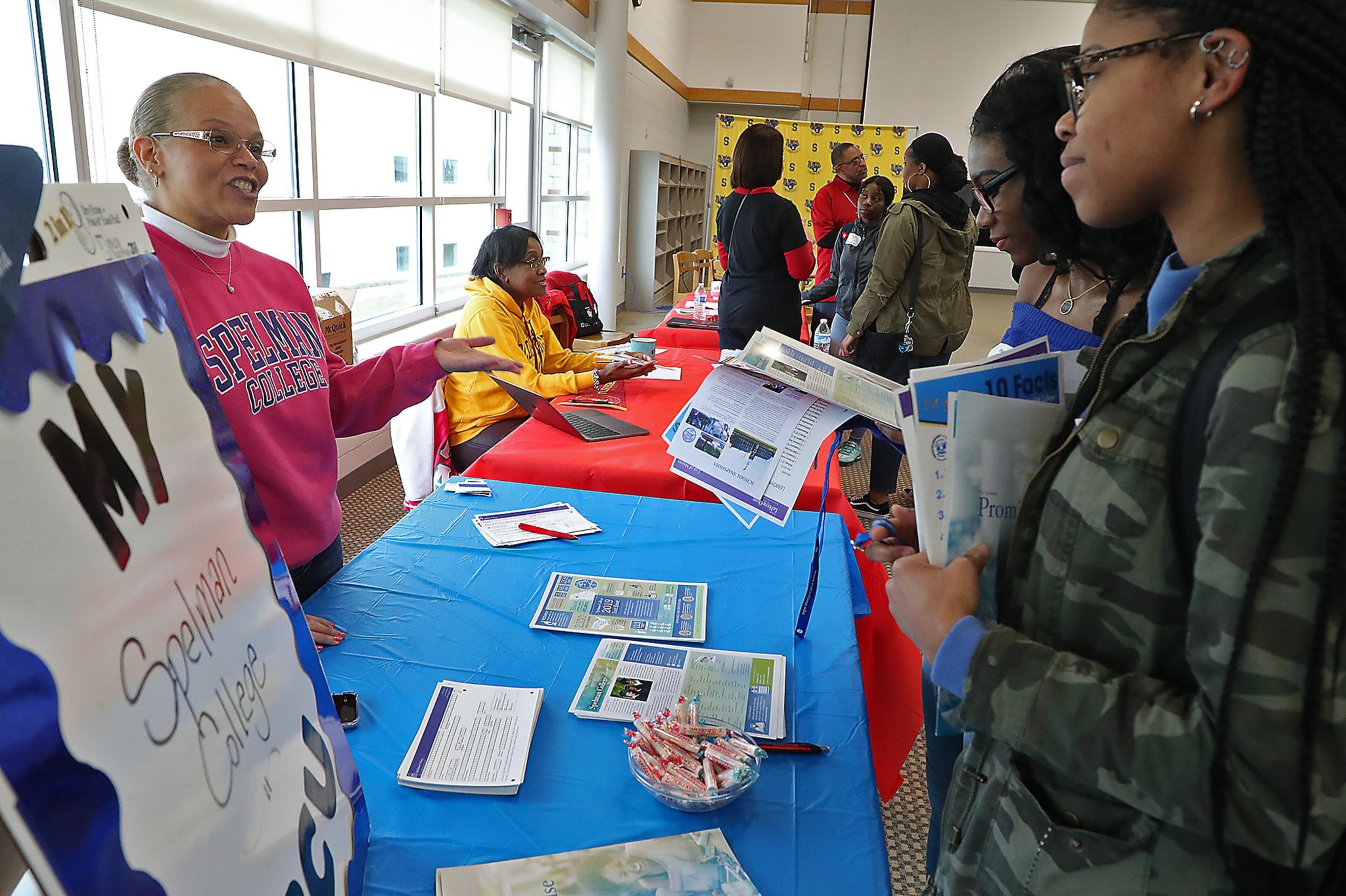 Springfield High School students Imani Fudge, left, and Nija Brown talk with Shannon Moore from Spelman College Friday during the HBCU Day at the school.