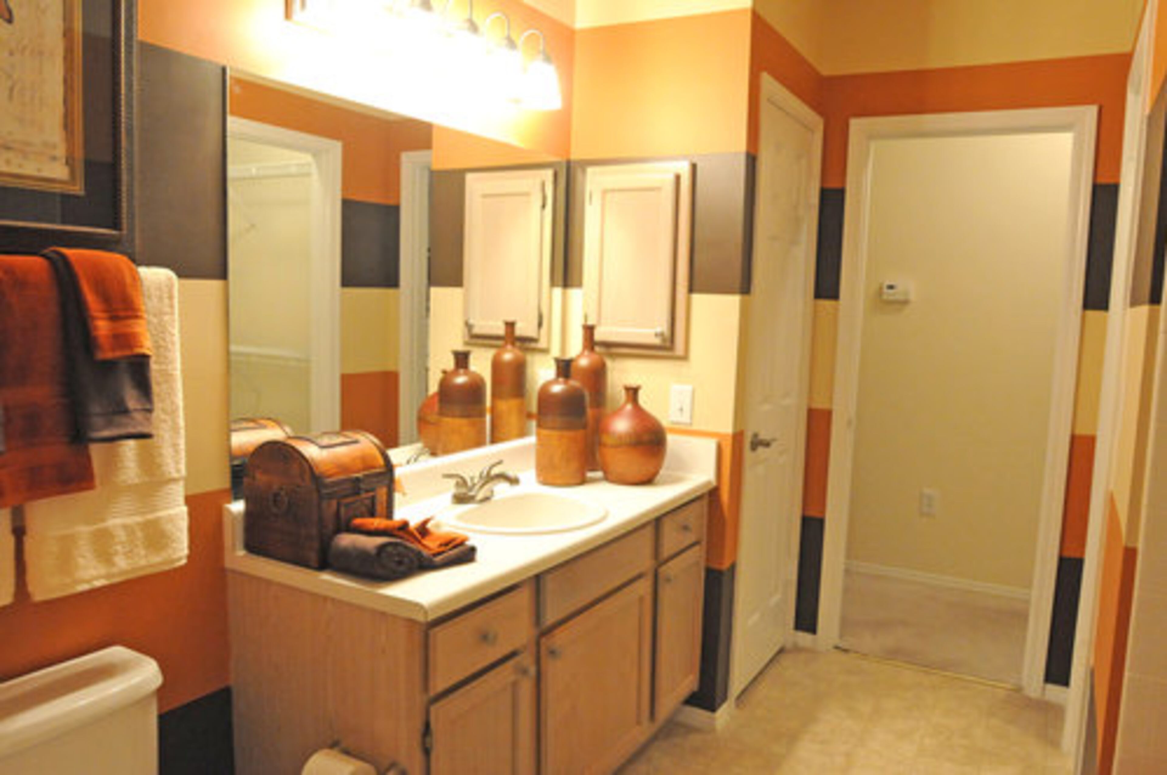 The bathroom features oversized full-mirrored vanities and oval bathtubs.