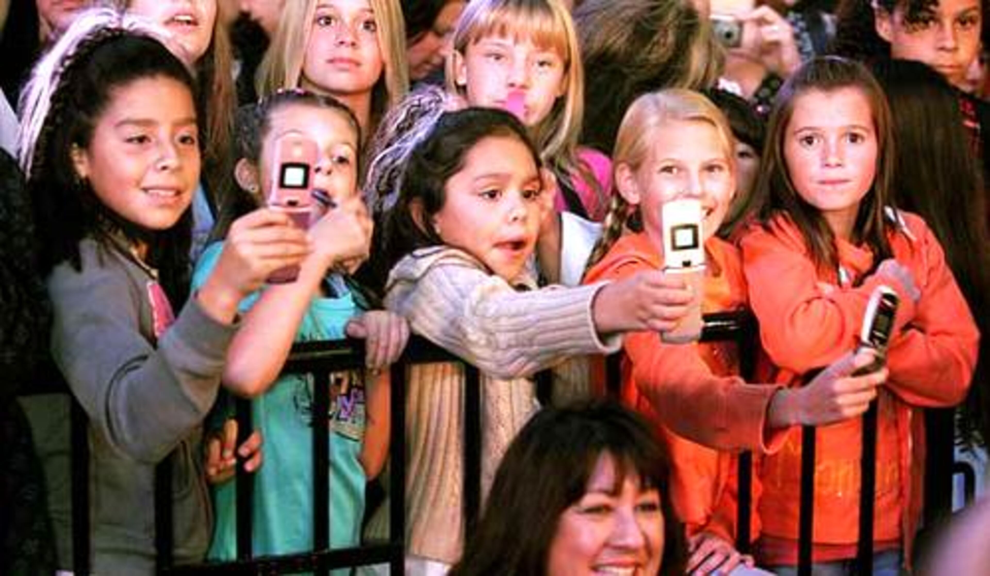 Young fans use cell phones to take photos of Mitchel Musso, a star of The Disney Channel's series "Hannah Montana," as fans of Miley Cyrus participate in the Ultimate Miley Party Bus Tour 2007 in Los Angeles on Nov. 7.