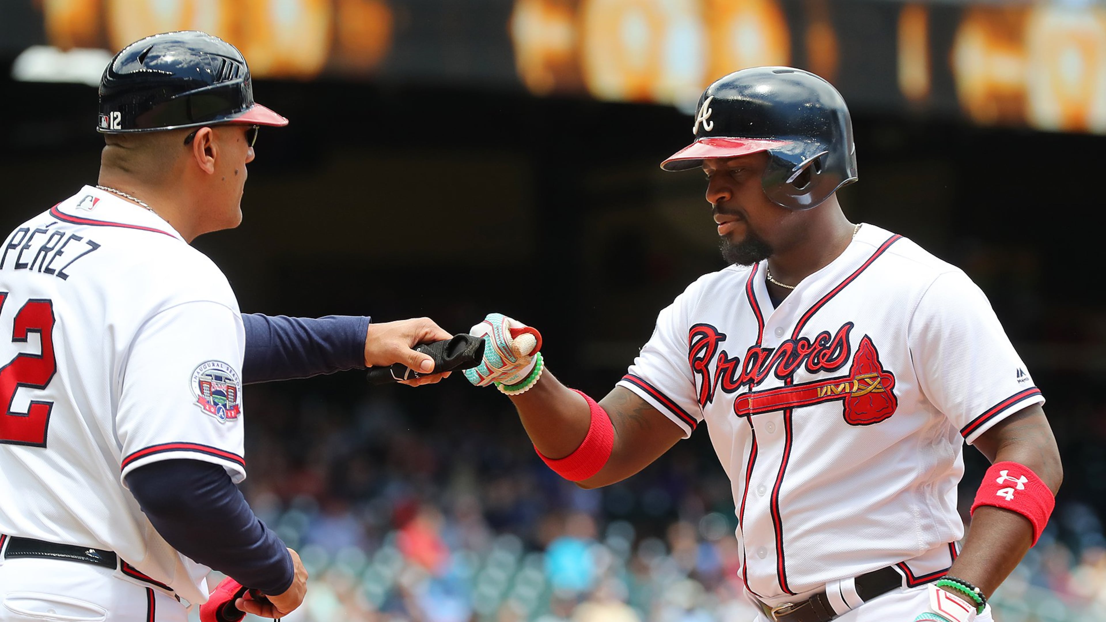 Braves second baseman Brandon Phillips, shown getting a fist bump from first-base coach Eddie Perez in a game last week, has missed consecutive starts for a right knee contusion but hopes to play Wednesday. (Curtis Compton/ccompton@ajc.com)